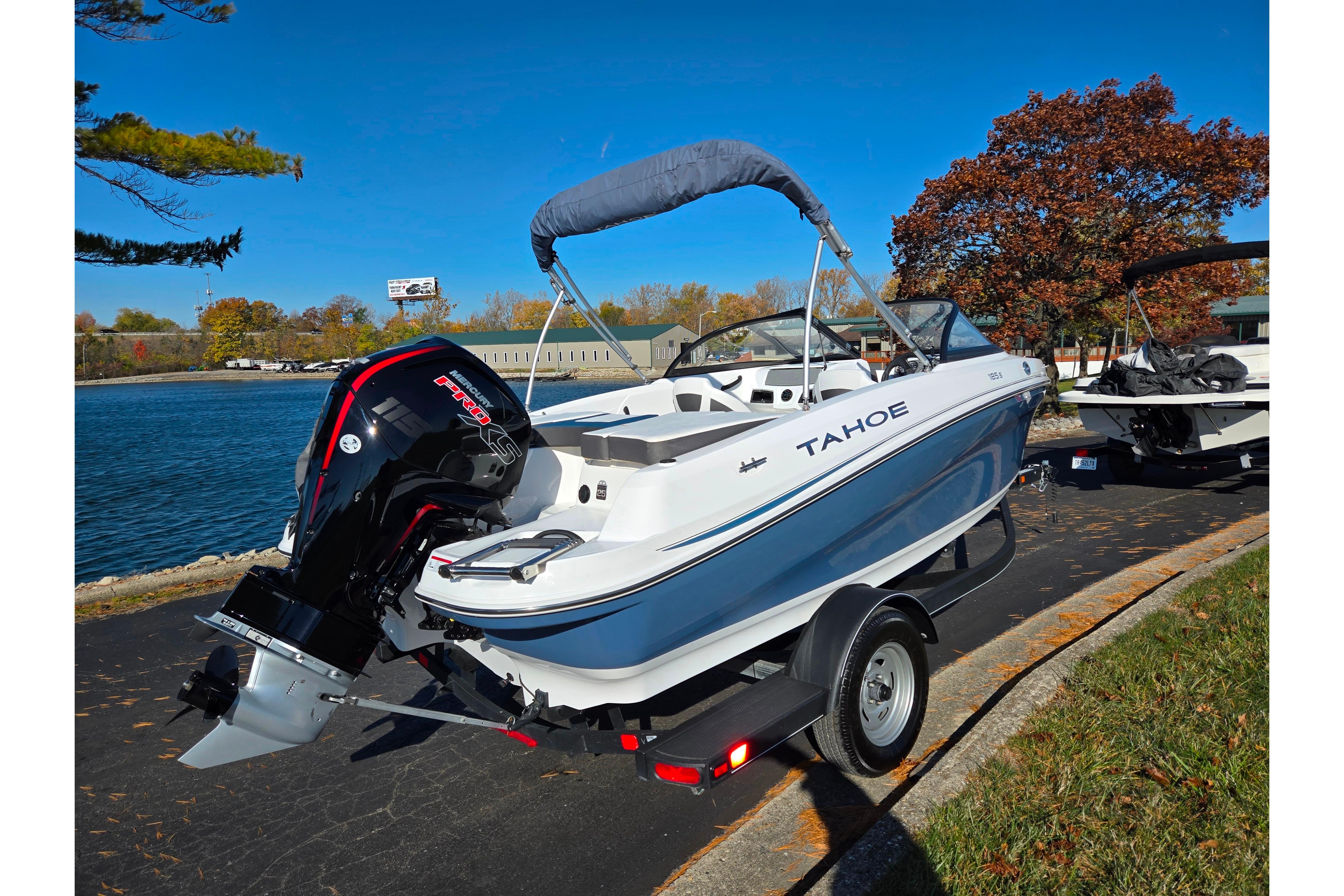 2023 Tahoe 185 S boat on trailer by a lakeside, under clear blue sky.
