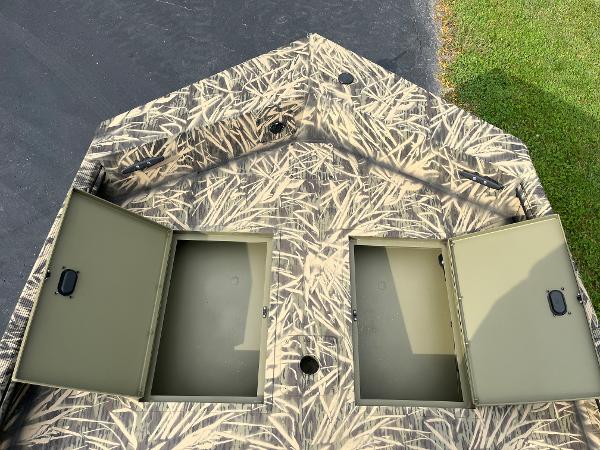 2024 Lowe Roughneck 1660 boat with open storage compartments and camouflage design.