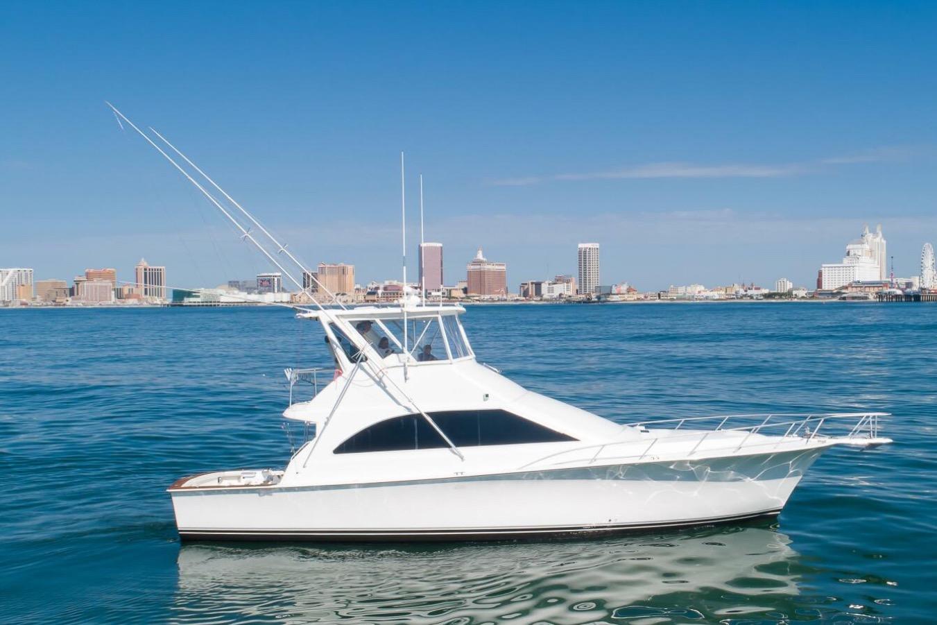 1999 Ocean Yachts 48 Super Sport on water with city skyline in background.