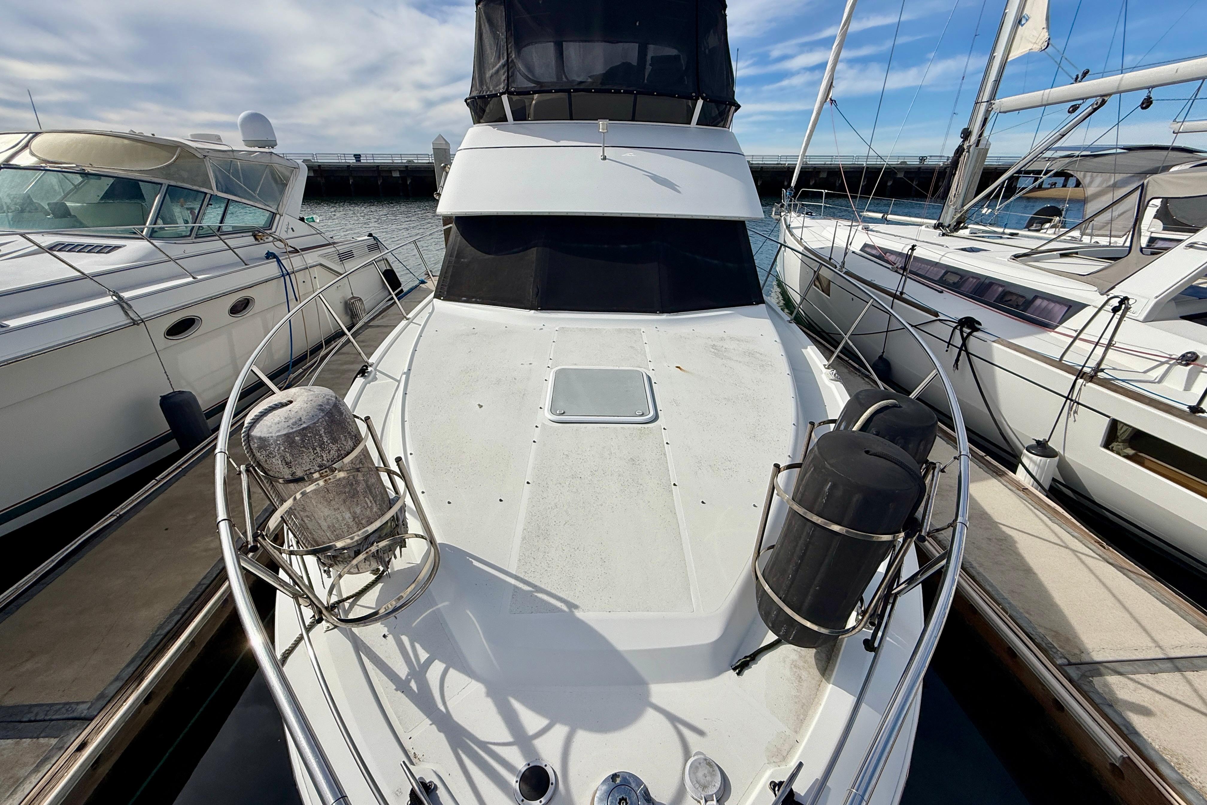 1997 Carver 355 Aft Cabin Motor Yacht docked between two boats.
