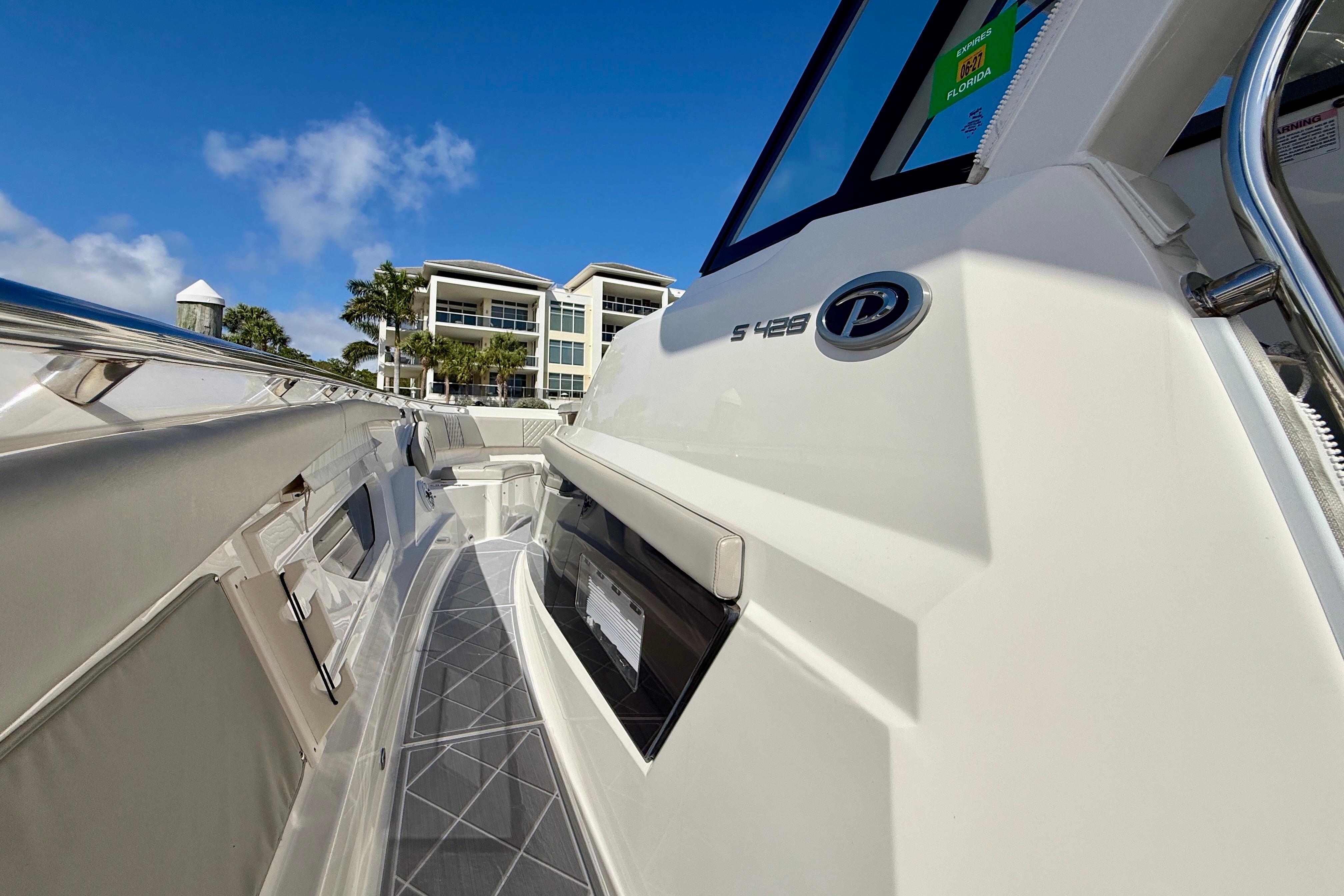 2022 Pursuit S 428 Sport boat docked near modern waterfront buildings.