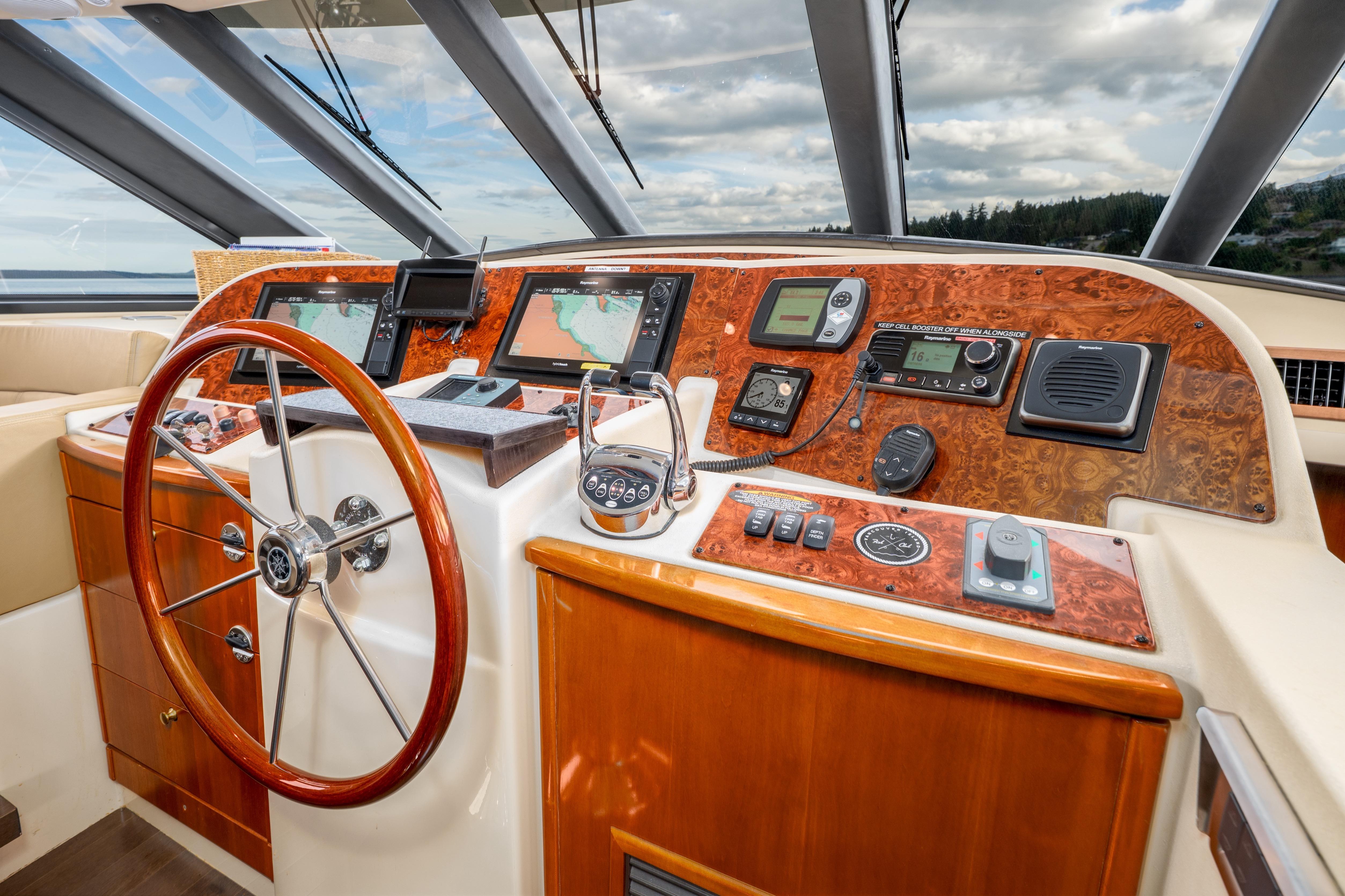 2007 Meridian 580 Pilothouse helm with navigation instruments and wooden steering wheel.