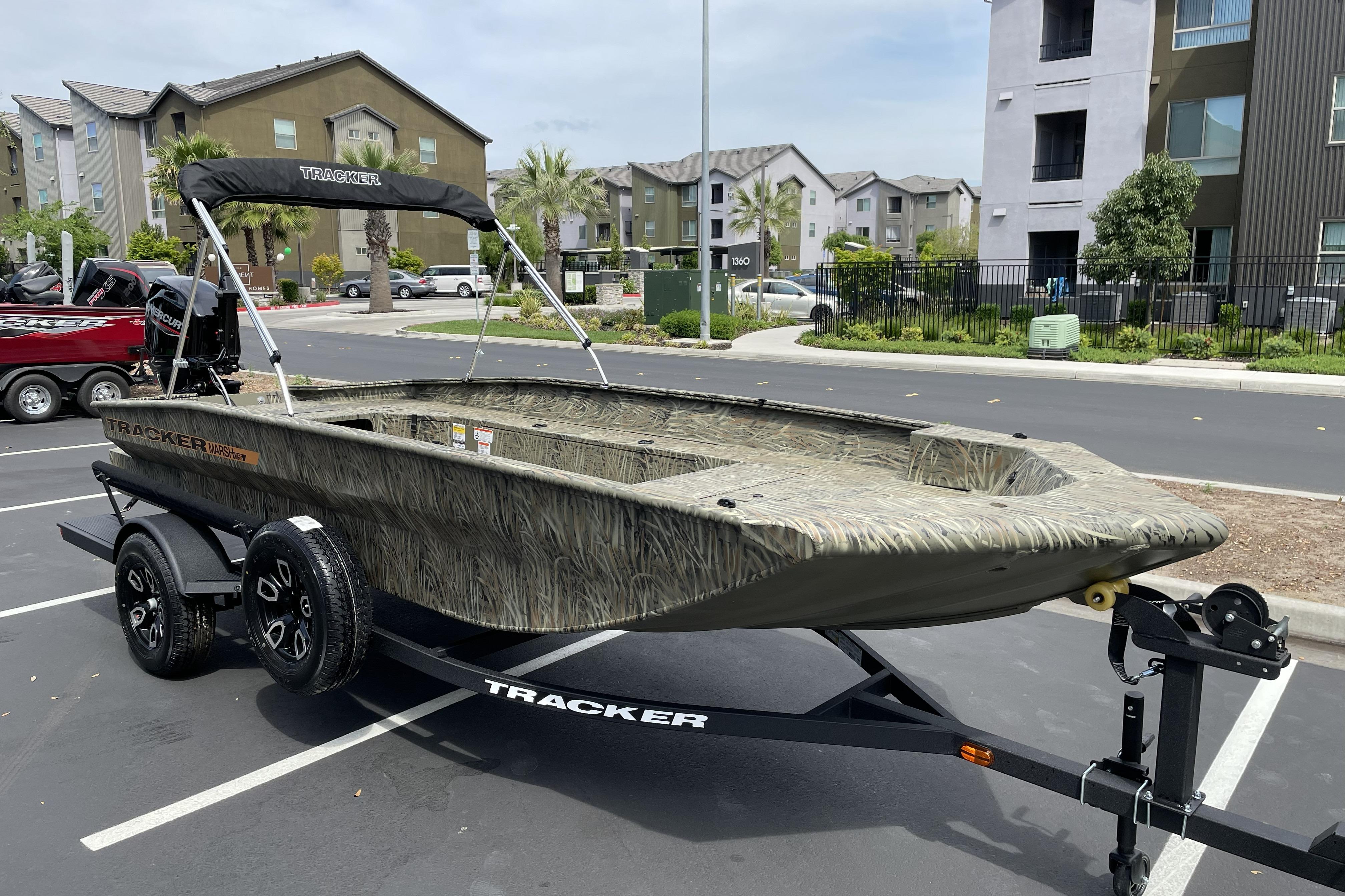 2026 Tracker Grizzly 1756 T Marsh boat on trailer in urban parking lot.