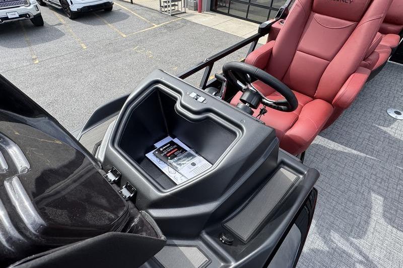 2026 Regency 230 DL boat dashboard with red captain's chair and steering wheel.