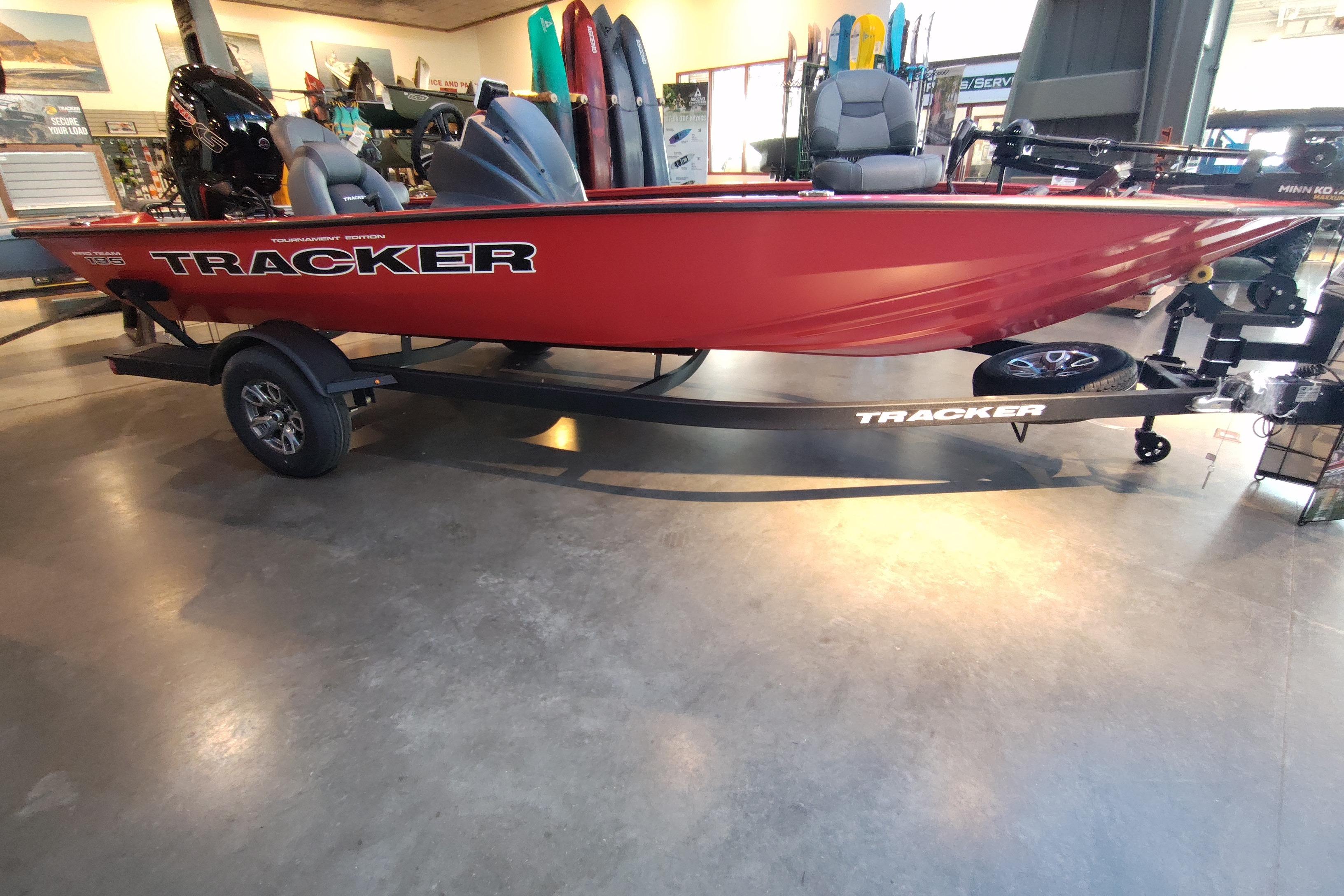 2026 Tracker Pro Team 195 boat in showroom, red exterior, on trailer.