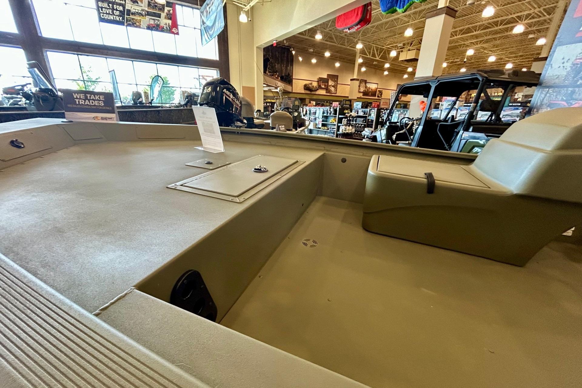 2026 Tracker Grizzly 1754 SC boat interior in showroom, featuring spacious seating and storage.