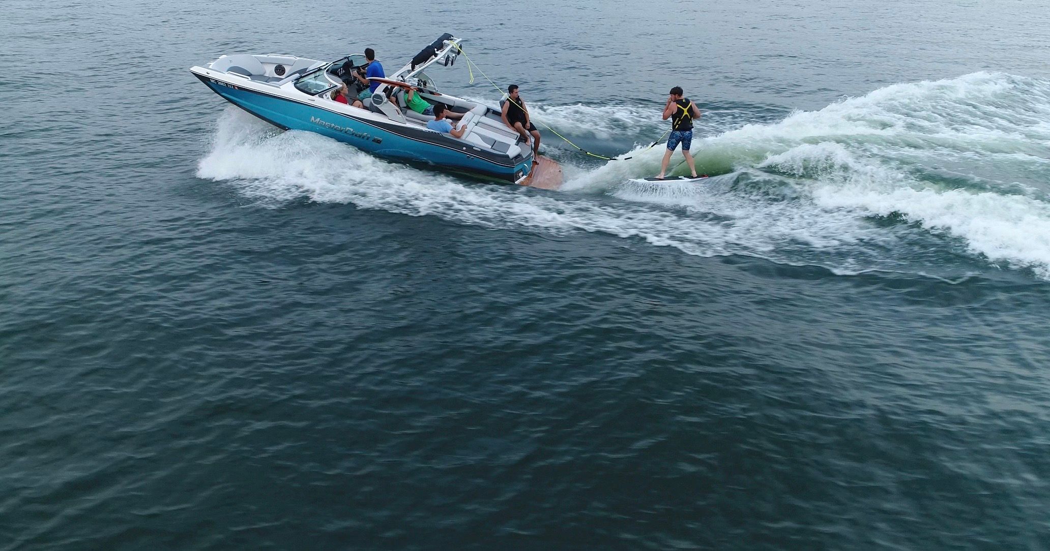 A 2019 MasterCraft XT22 towing a wakeboarder over calm water.