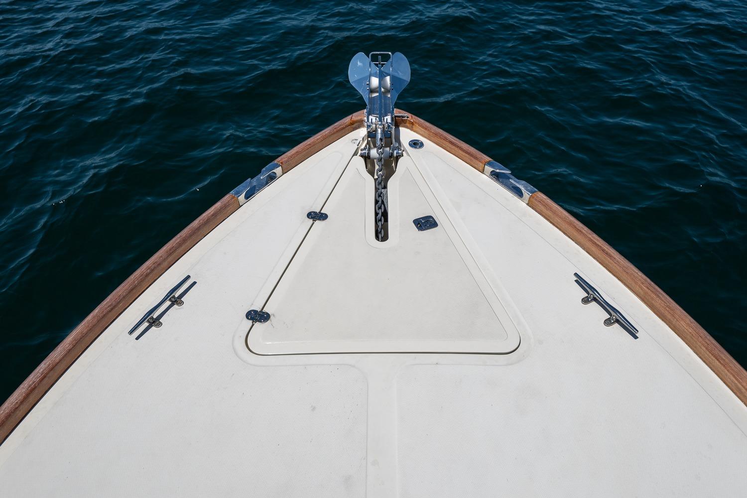 Bow of 2001 Hinckley Picnic Boat 36 Classic on calm water.