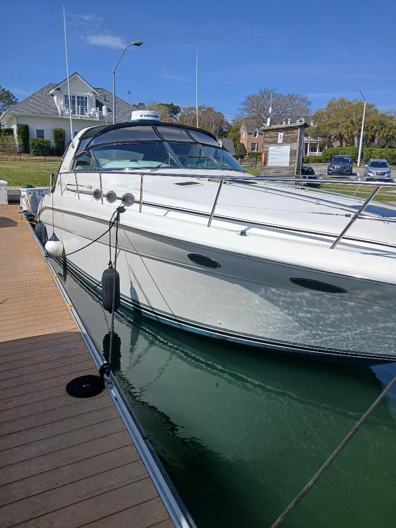 1997 Sea Ray 370 Sundancer docked, showcasing sleek design and white exterior.