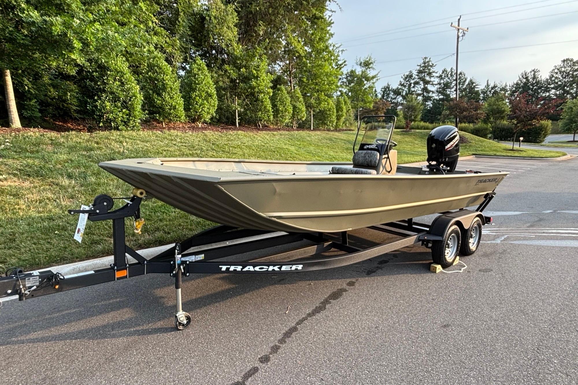 2026 Tracker Grizzly 2072 CC boat on trailer, parked on a road near greenery.