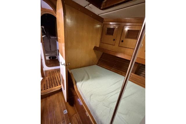 1980 Mao Ta Skye 51 yacht cabin with wooden interior and cozy bed.