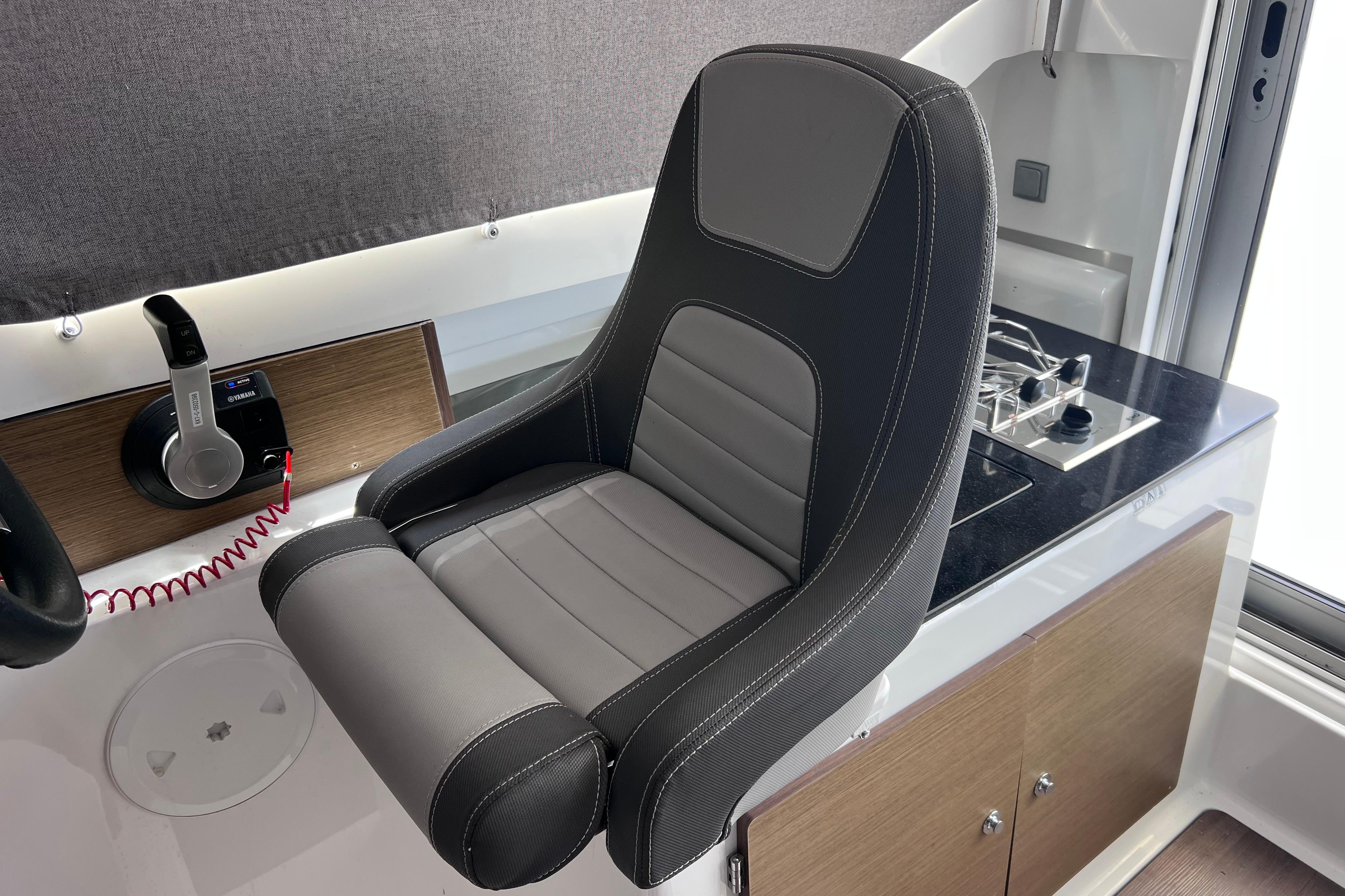 Captain's seat and helm controls in 2021 Jeanneau NC Weekender 795 Series 2 boat.