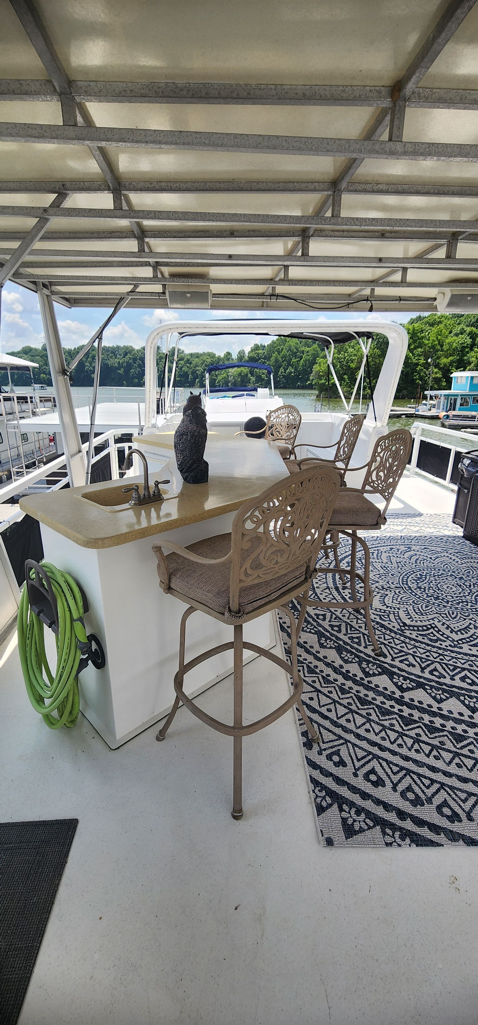 The image shows a yacht deck with bar stools and a counter.