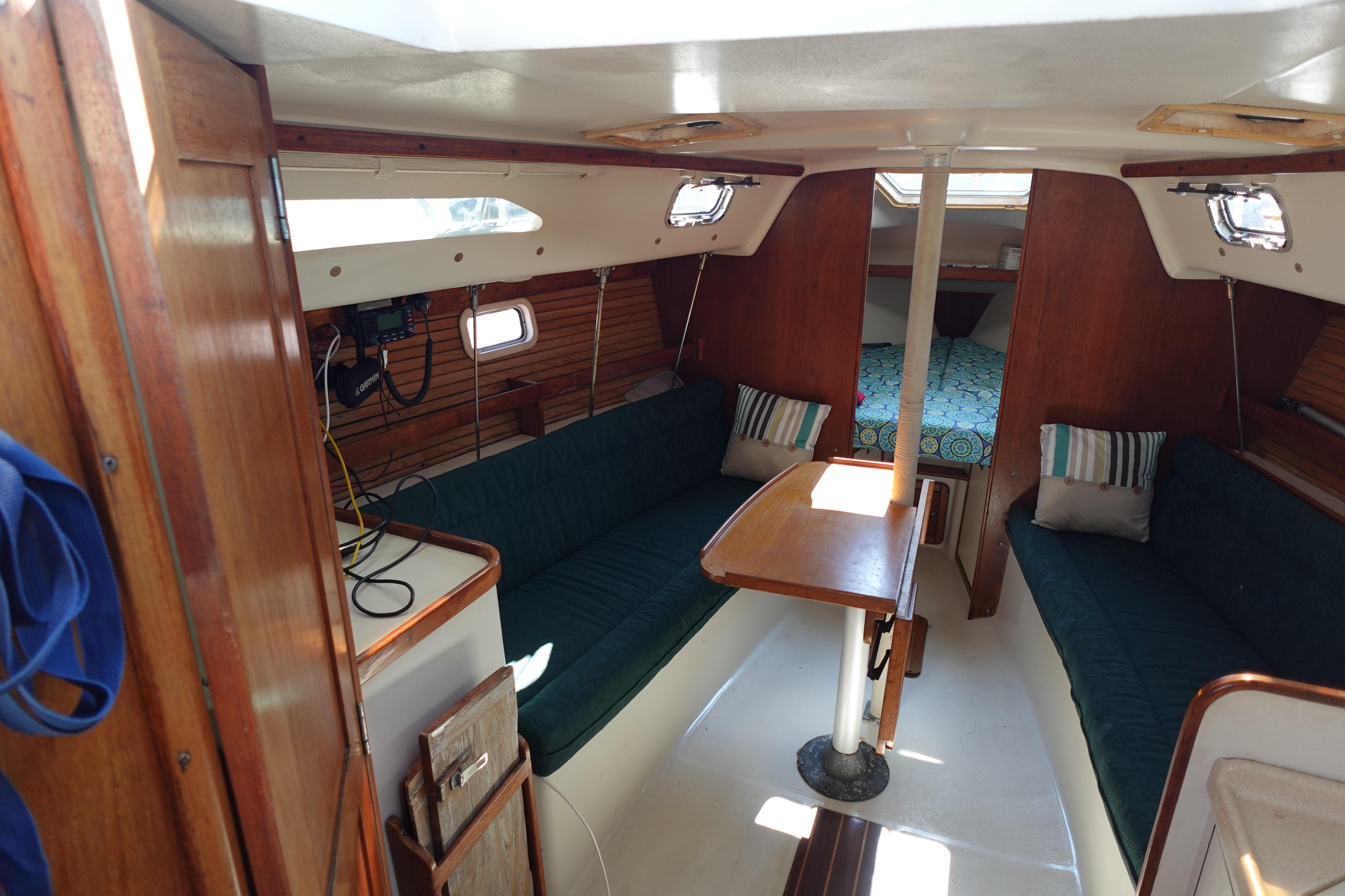 Interior of a 1997 Catalina 28 sailboat with cozy seating and wooden finishes.