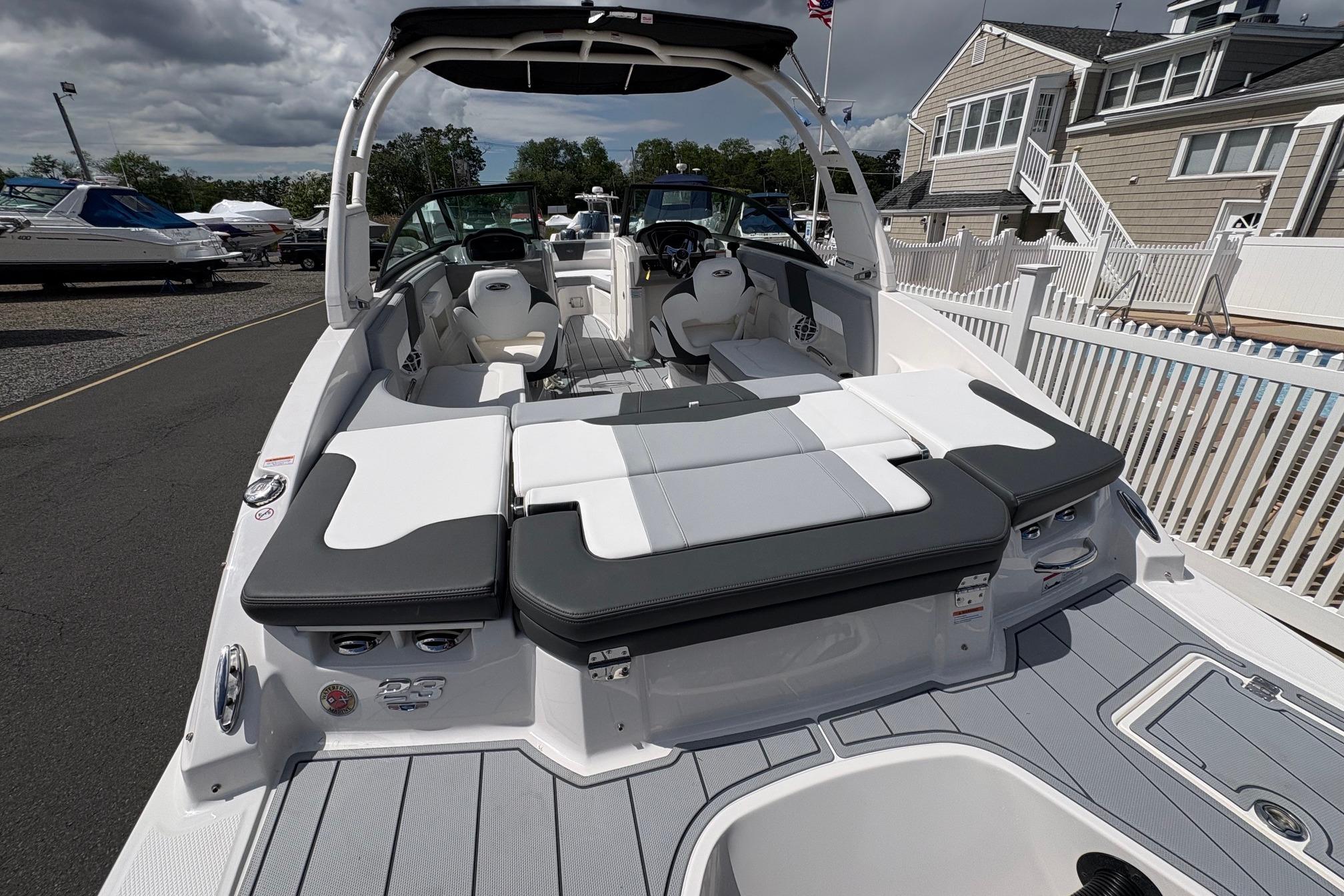 2026 Chaparral 23 SSi OB boat with spacious seating and modern design at a marina.