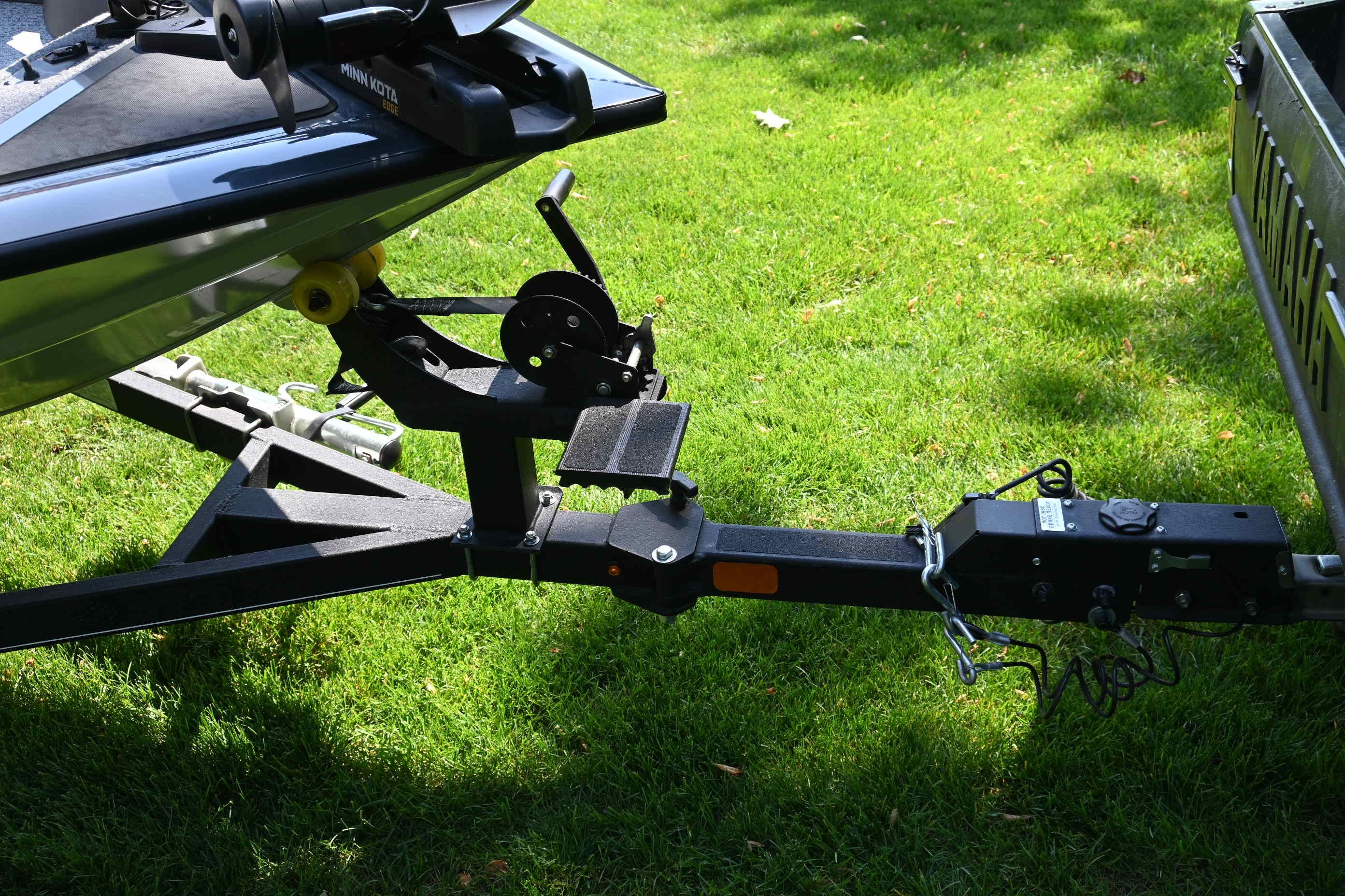 Trailer of a Tracker Pro 175 TF boat on grass.