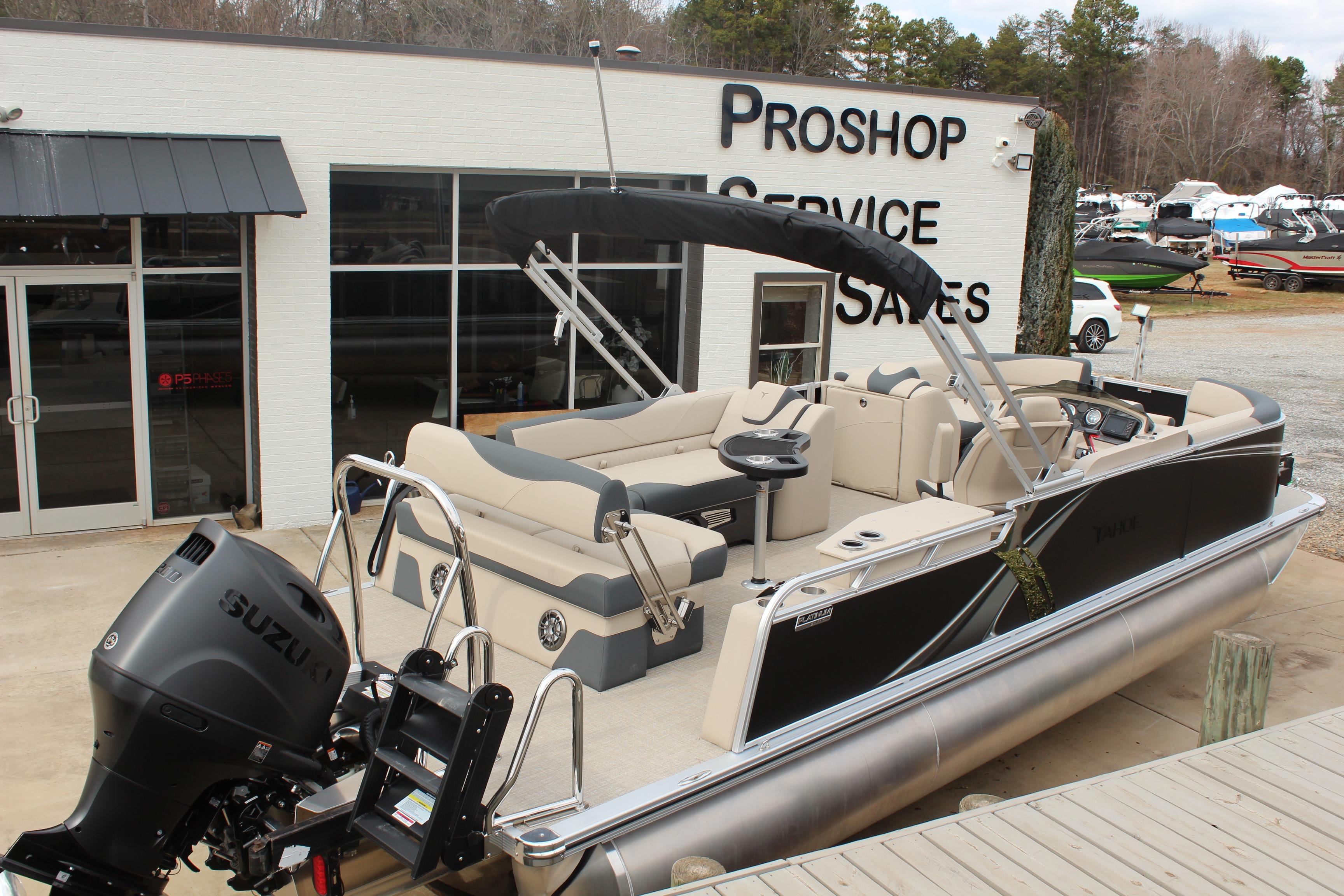 2026 Tahoe Pontoon LTZ boat displayed at a pro shop service and sales center.