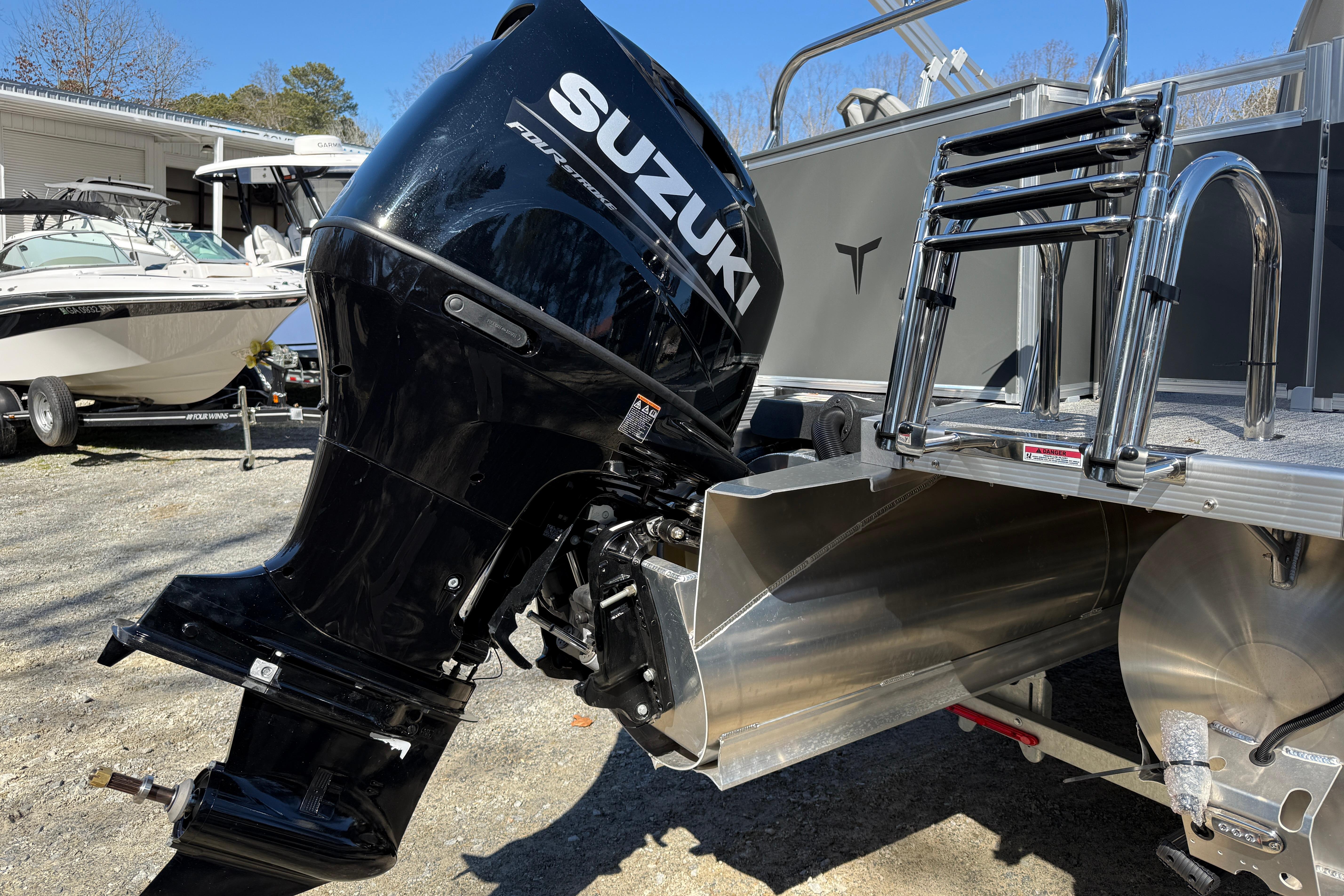 2026 Tahoe Pontoon Sport 85 Rear Fish with Suzuki outboard motor, parked outdoors.