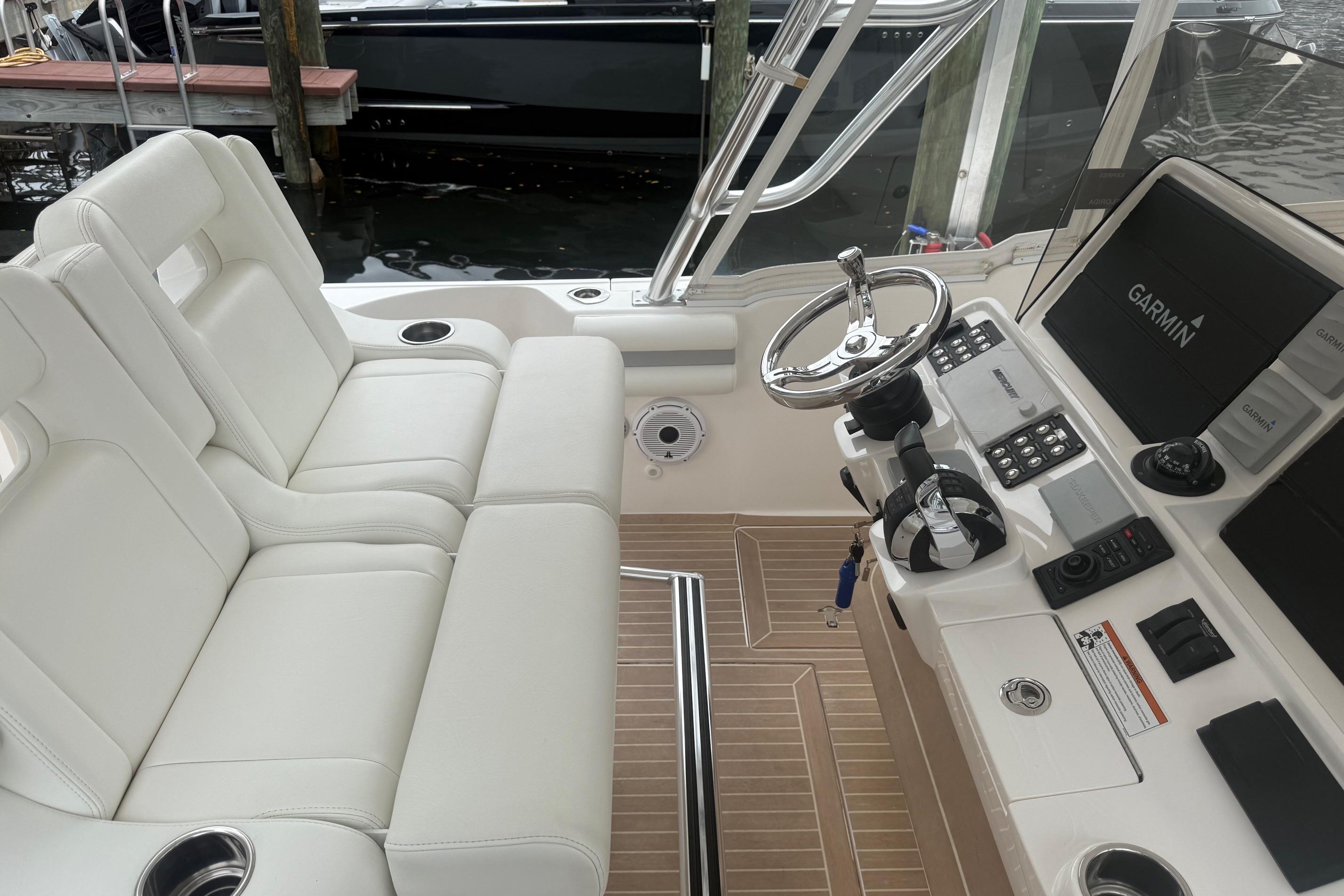 2021 Intrepid 409 Valor boat interior with white seating and Garmin navigation system.