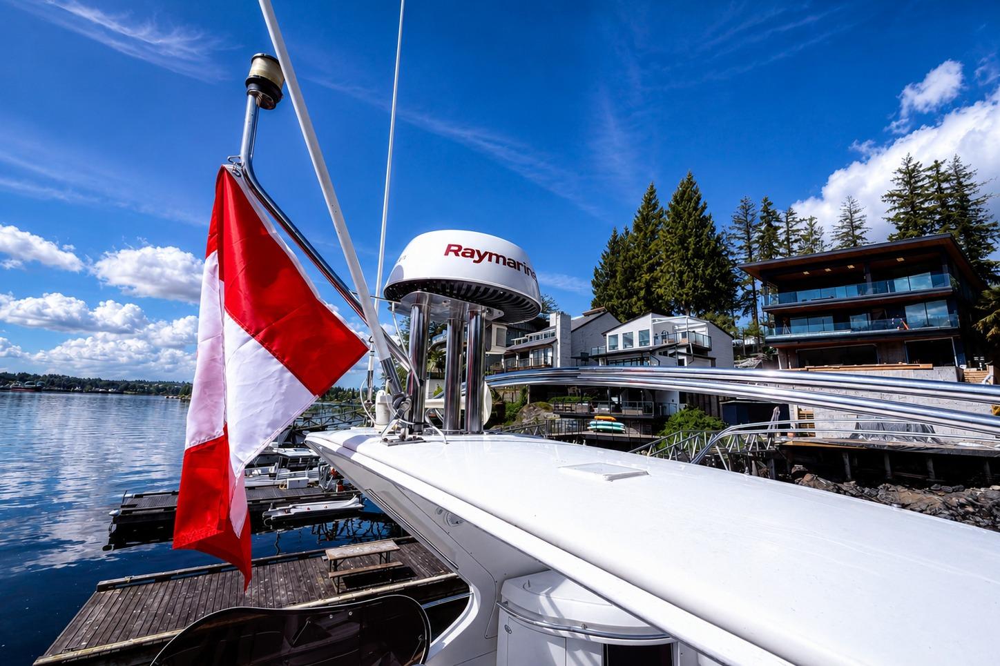Azimut Fly 62 yacht, 2005 model, docked by waterfront homes under a clear blue sky.