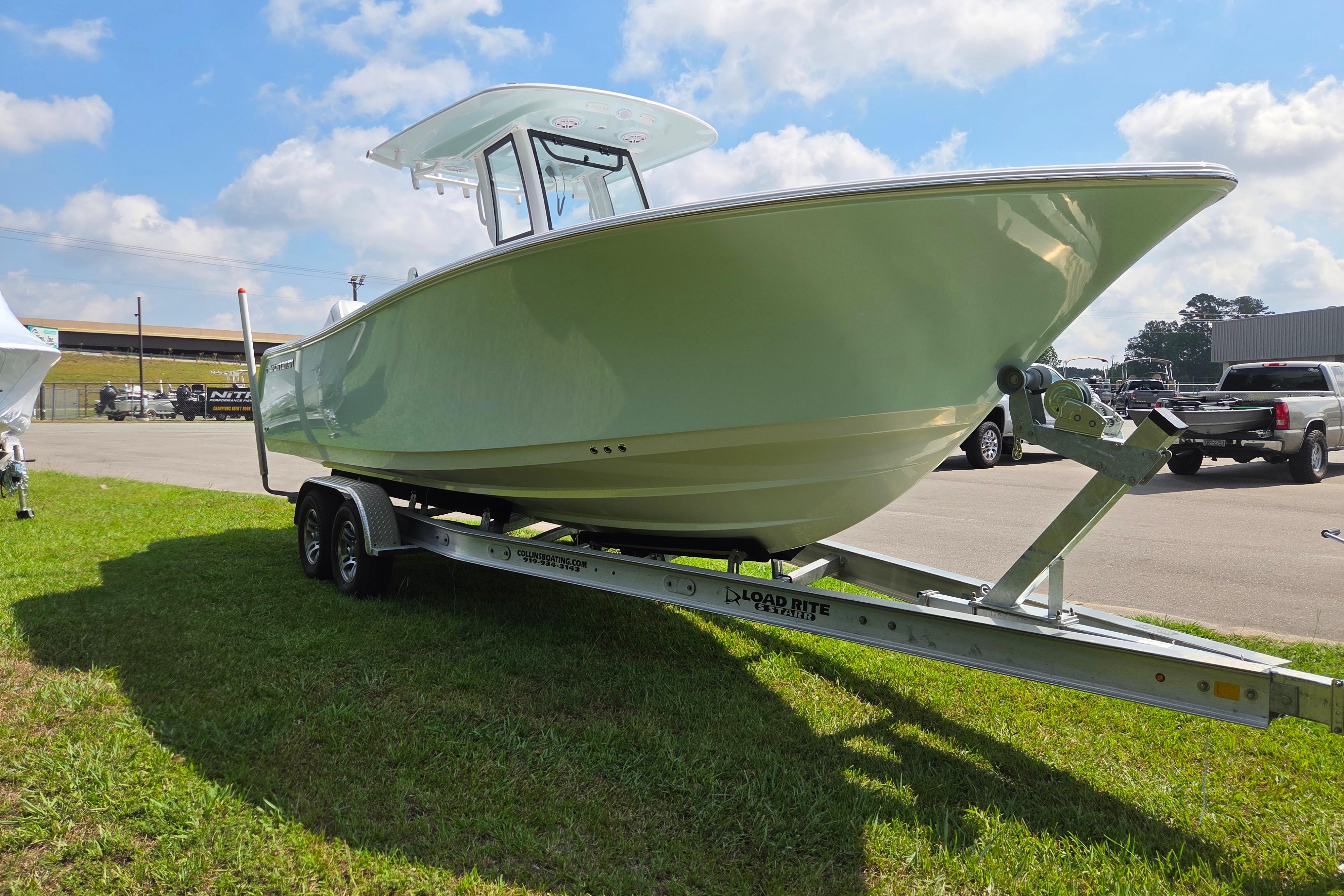 2026 Sportsman Open 252 Center Console boat on trailer, parked outdoors.