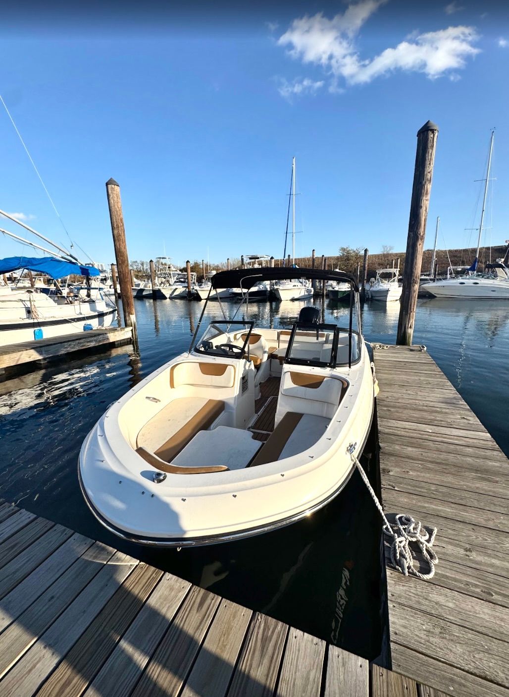 A 2019 Bayliner VR4 Bowrider OB docked at a wooden pier in a marina.