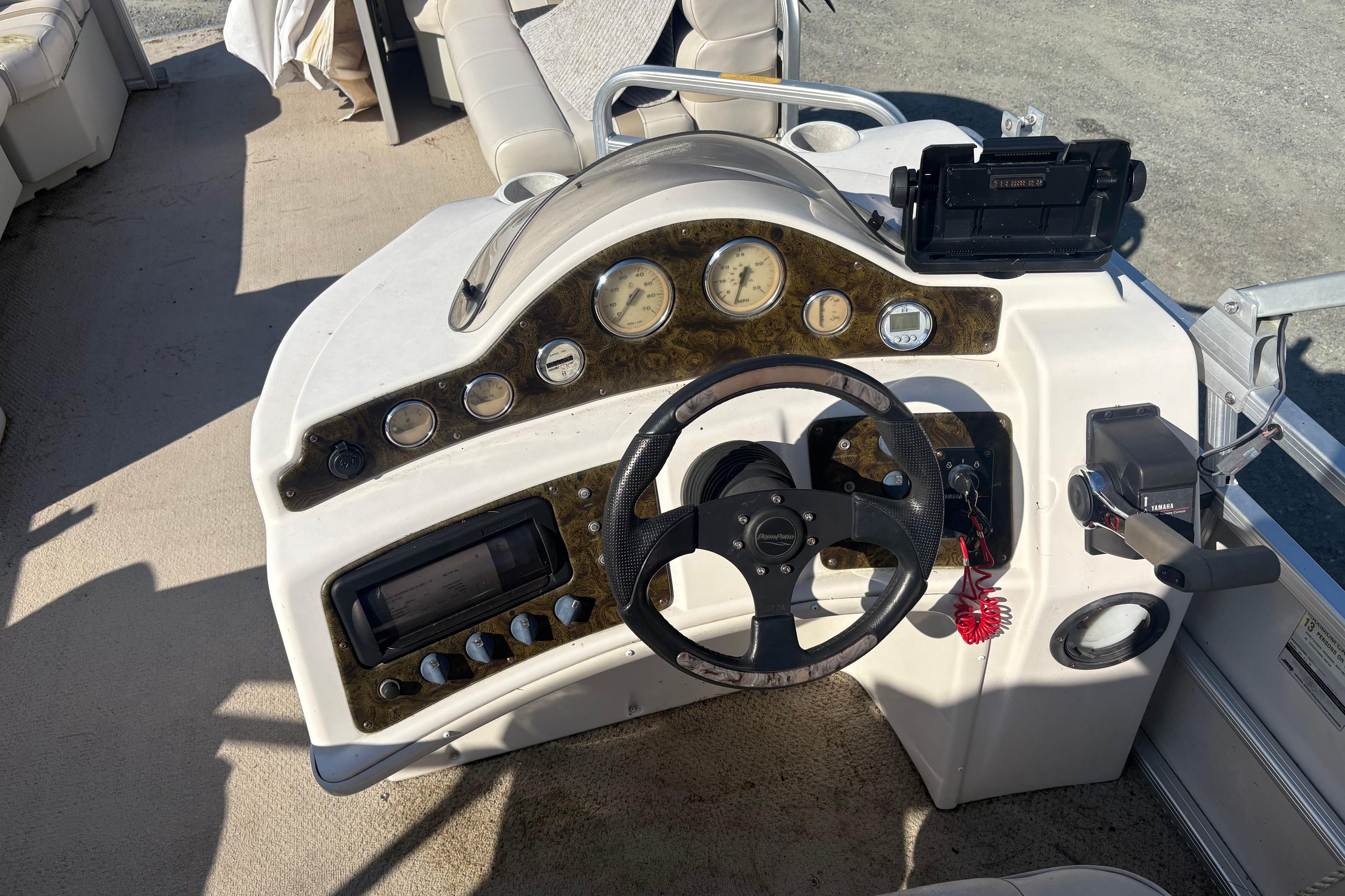 2003 Aqua Patio 200RE boat dashboard with steering wheel and control panel.