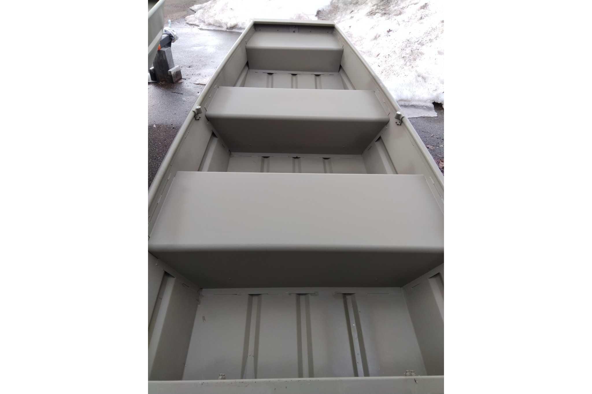 2026 Tracker Grizzly 10 Jon boat interior with bench seats, parked on snowy pavement.