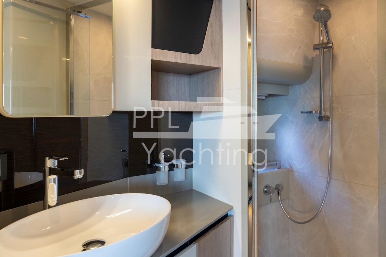Modern bathroom interior on 2021 Absolute 47 Fly yacht, featuring sleek sink and shower.