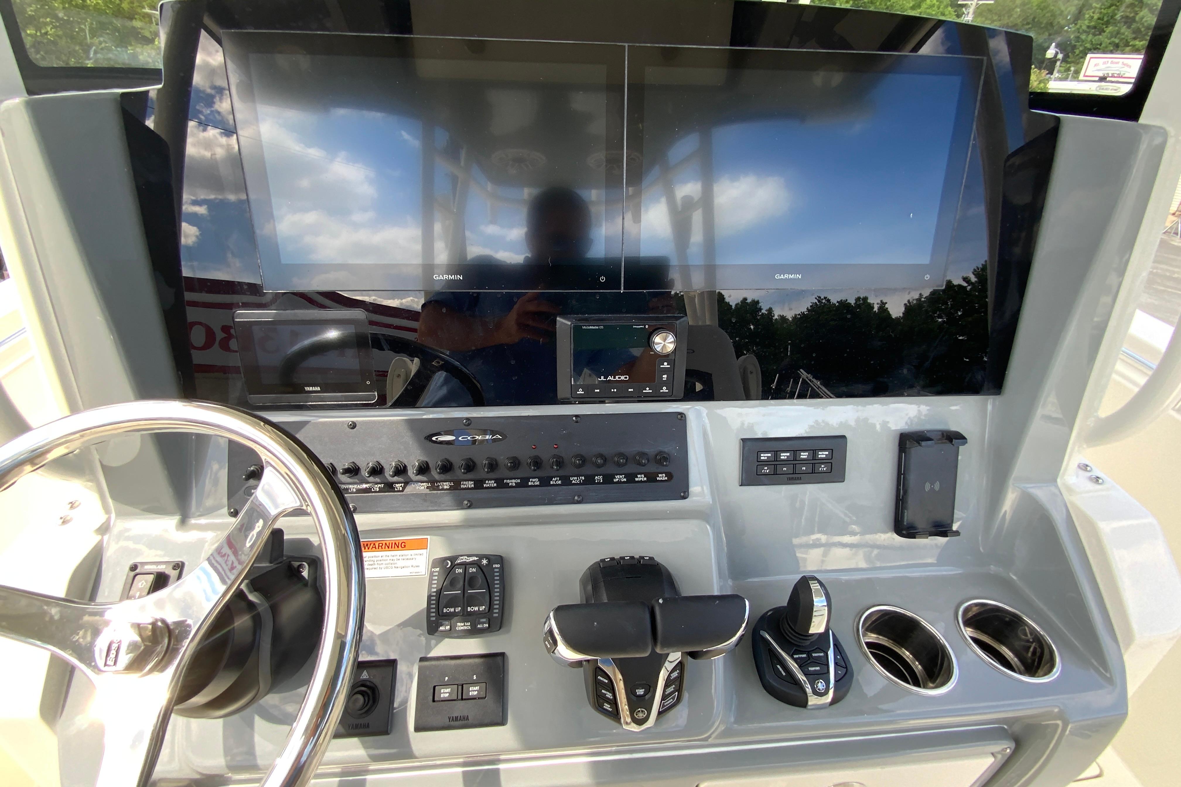 Helm of 2027 Cobia 320 Center Console with dual Garmin displays and modern controls.