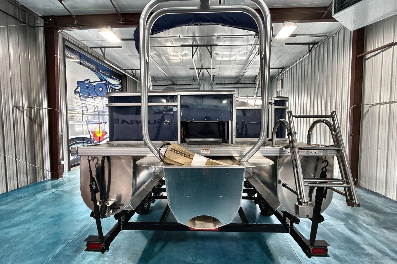 2026 Landau Island Breeze 23F pontoon boat in a showroom, rear view.
