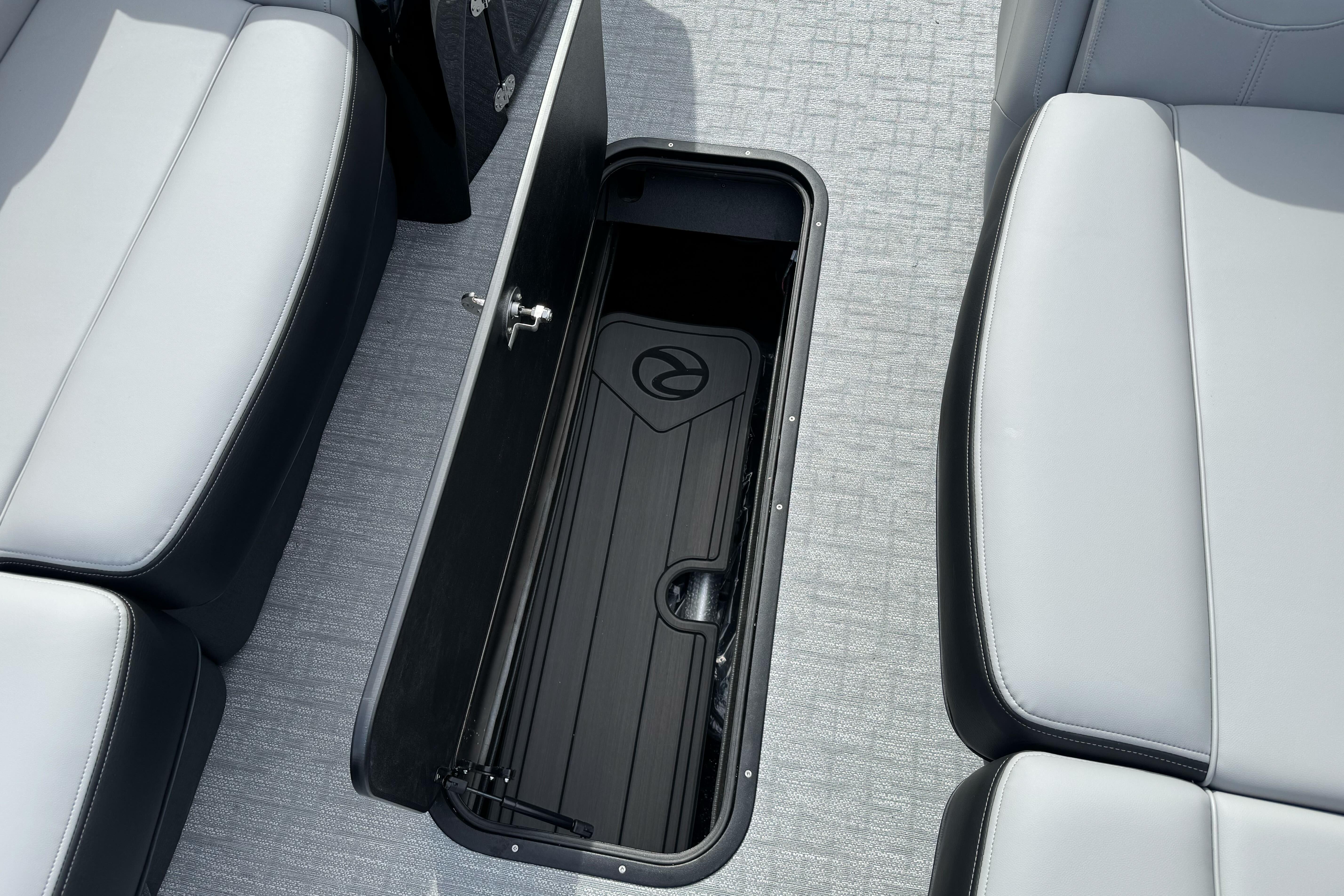 2026 Regency 250 DL boat interior with open storage compartment and cushioned seating.