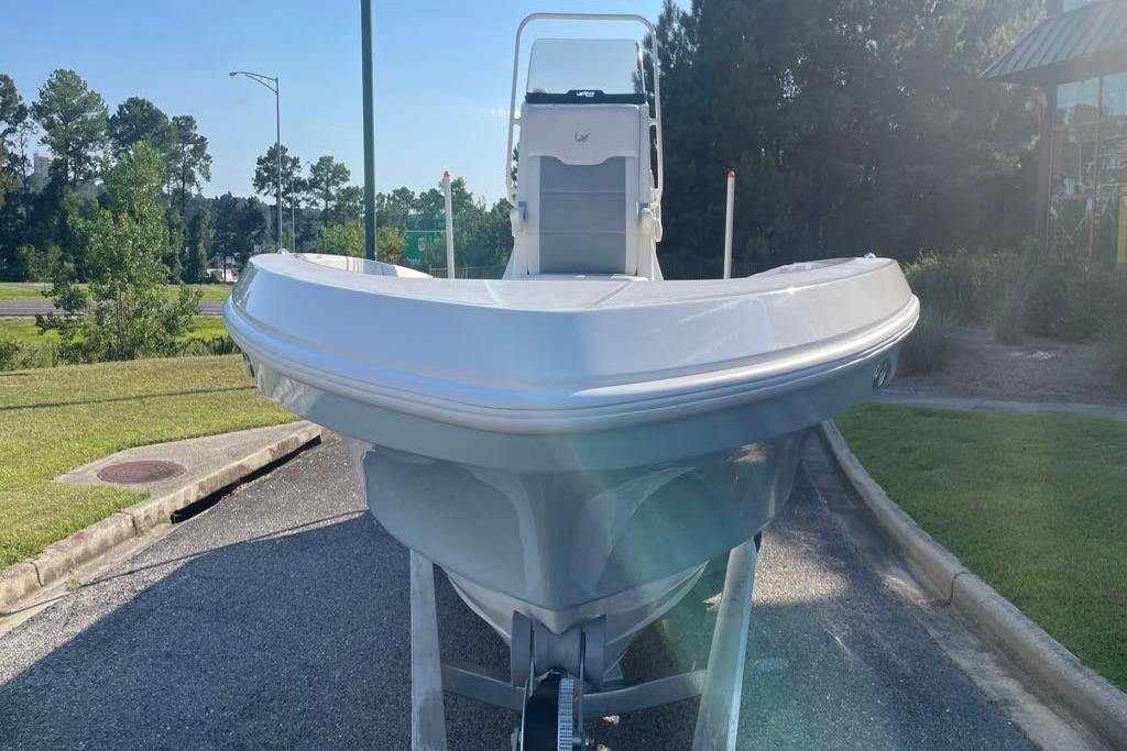 2026 Mako 24 APEX boat on trailer, parked outdoors in sunny setting.
