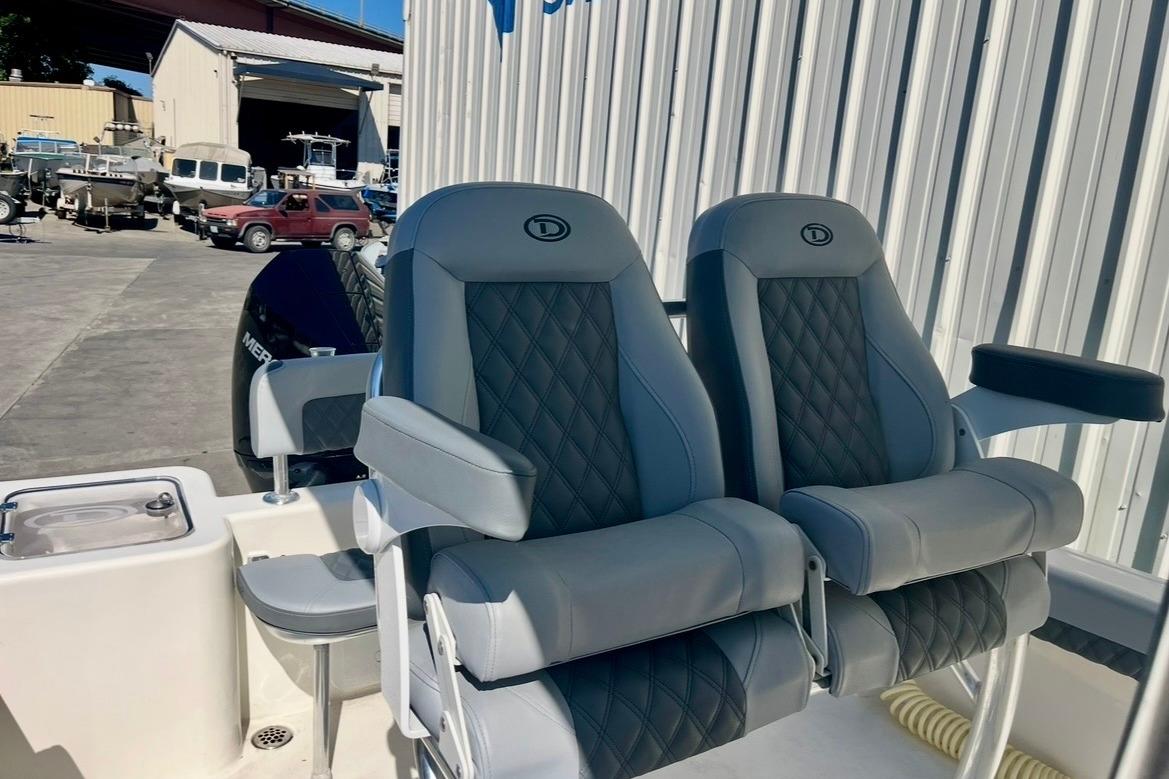 Luxury seating on 2025 Defiance Catalina 240 boat, featuring quilted upholstery and armrests.