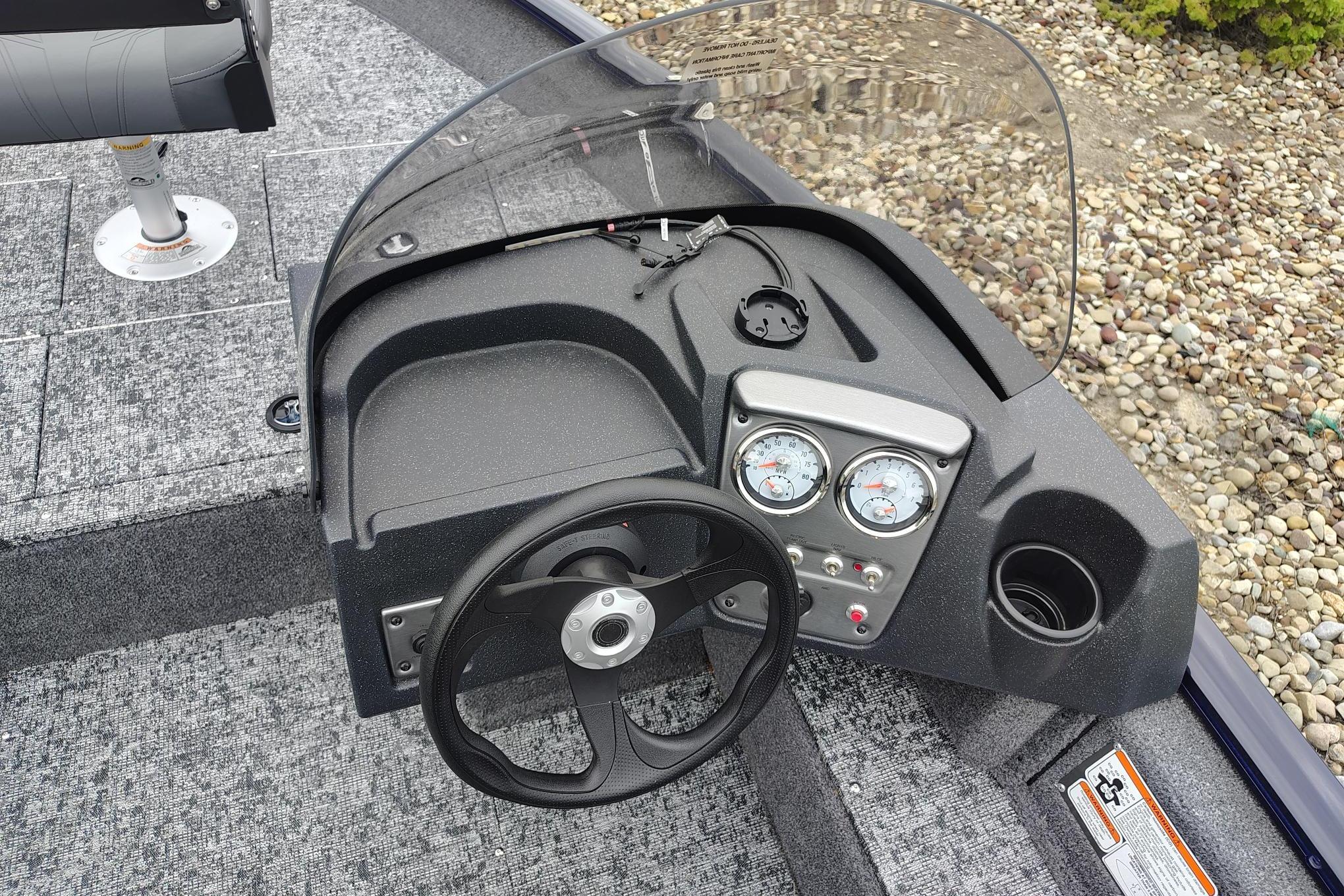 Steering console of 2026 Tracker Pro Guide V-16 SC boat with gauges and windshield.