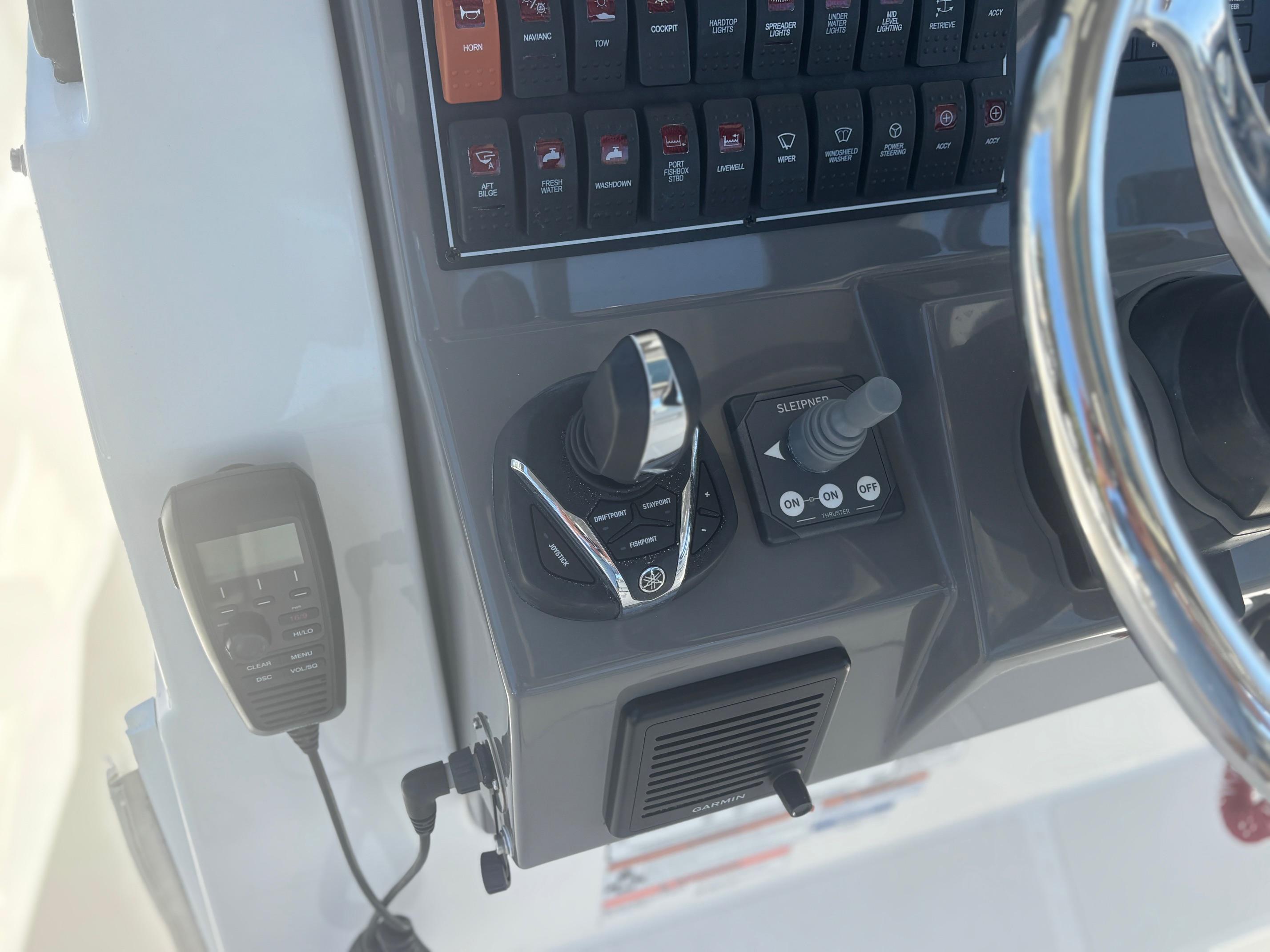 Control panel of 2022 Pursuit S 288 boat with steering wheel and joystick.