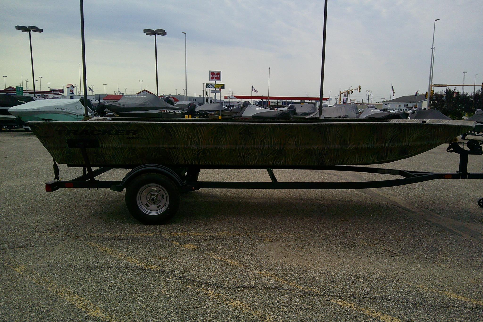 2026 Tracker Grizzly 1860 Utility boat on trailer in parking lot.