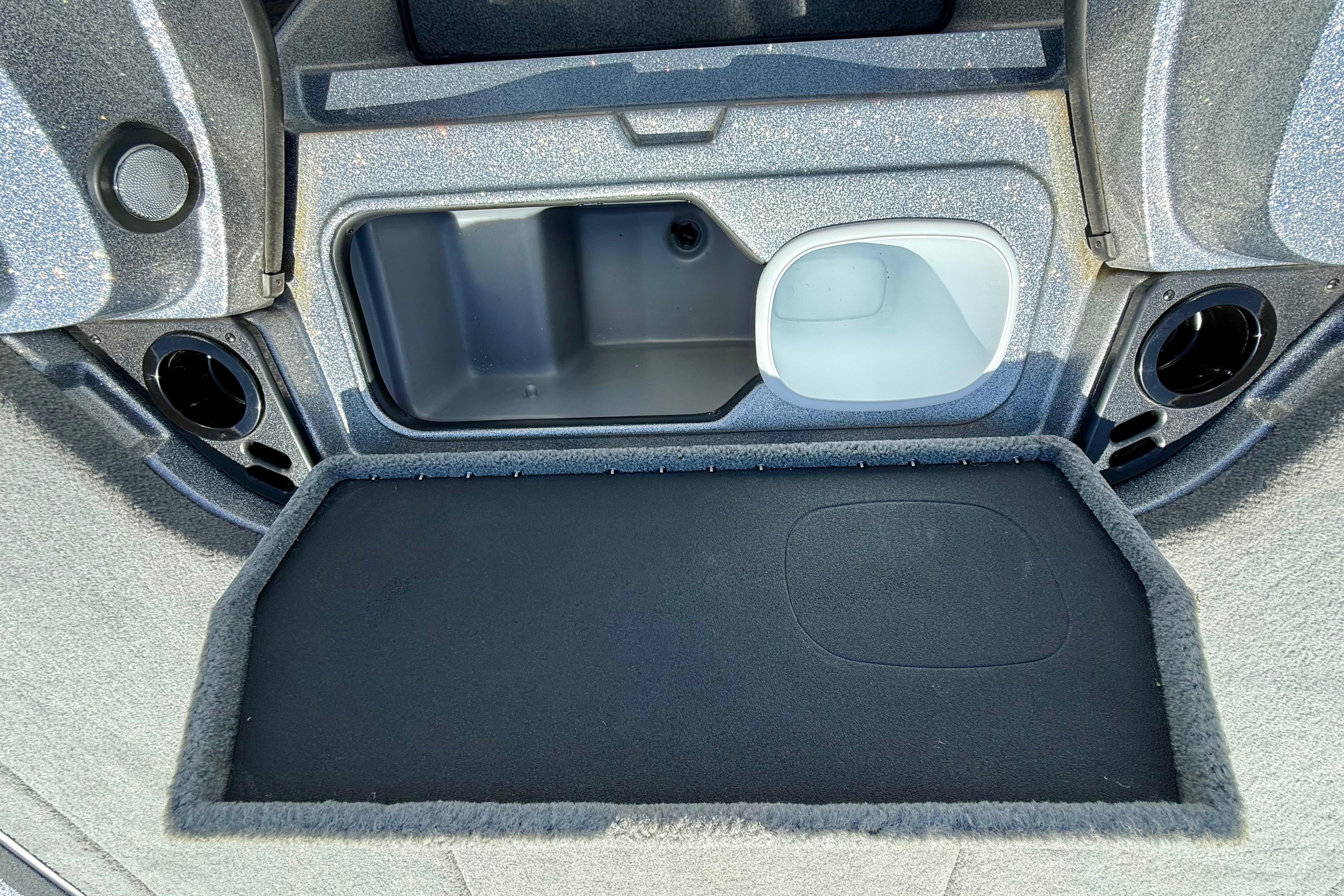 2026 Nitro Z19 XL boat storage compartment with carpeted lid and cup holders.