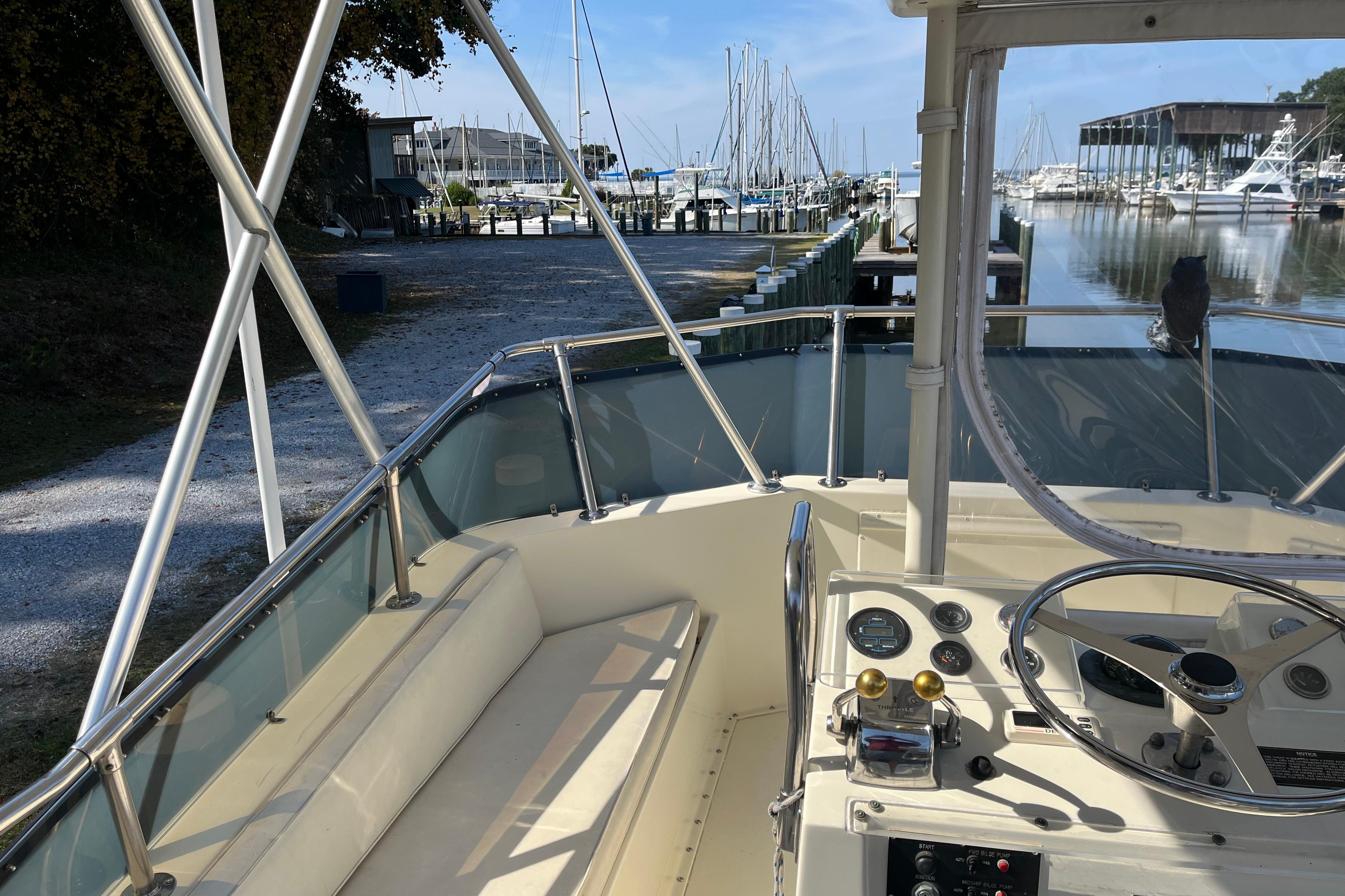 1987 Hatteras 41 Convertible boat interior at marina, showcasing helm and seating area.
