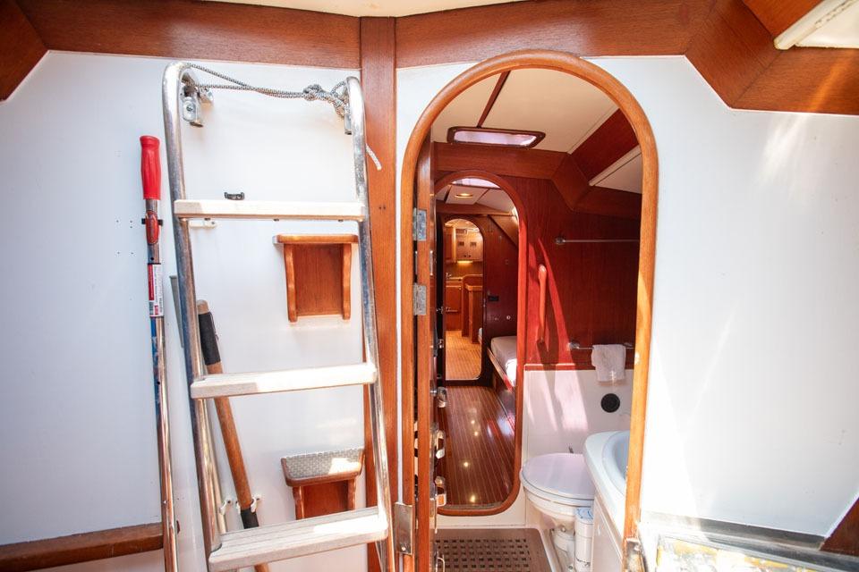 Interior of 1990 Nautor Swan 59 yacht, featuring wooden finishes and compact design.