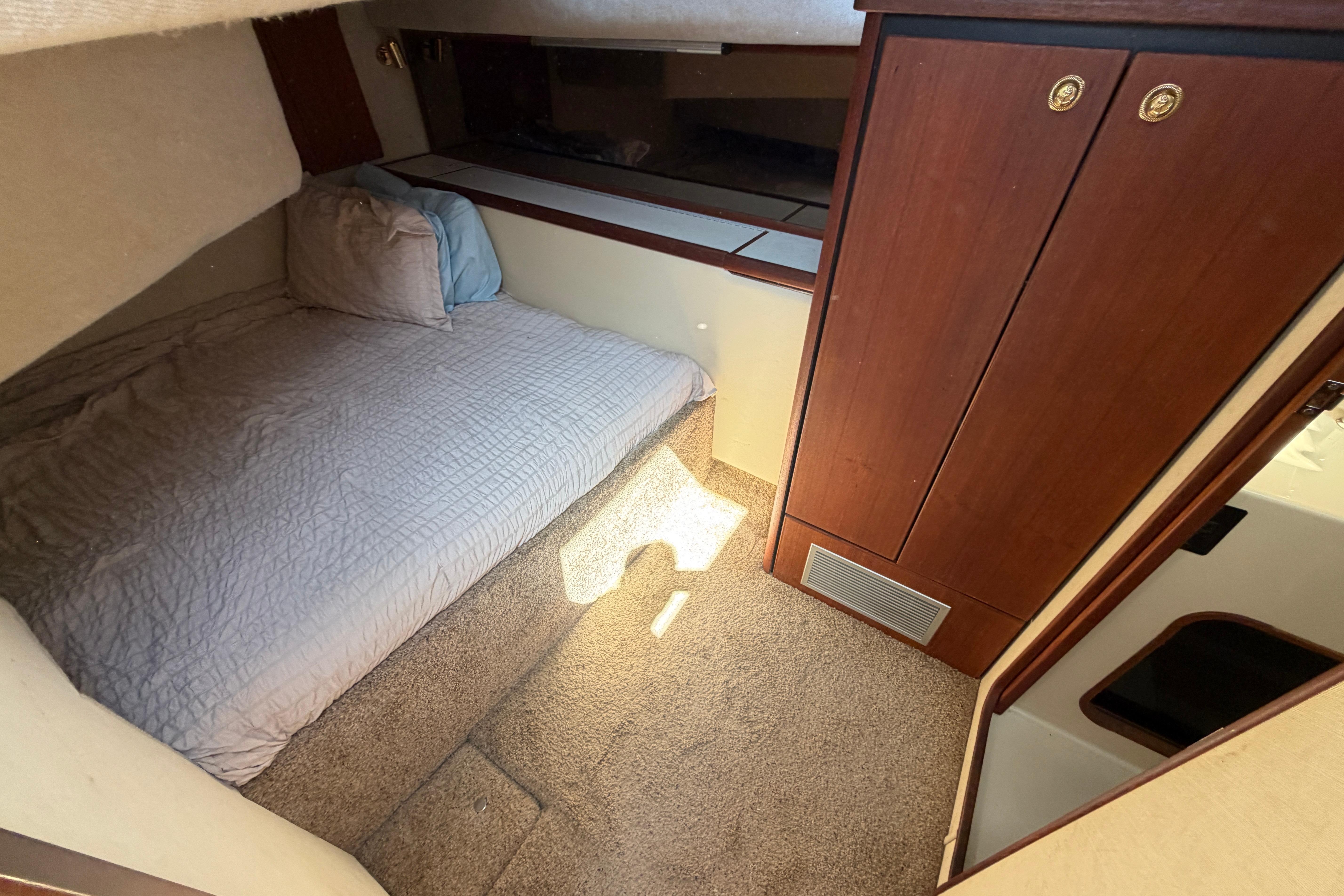Cozy cabin interior of 1994 Bayliner 3888 MY Sedan with bed and wooden cabinetry.