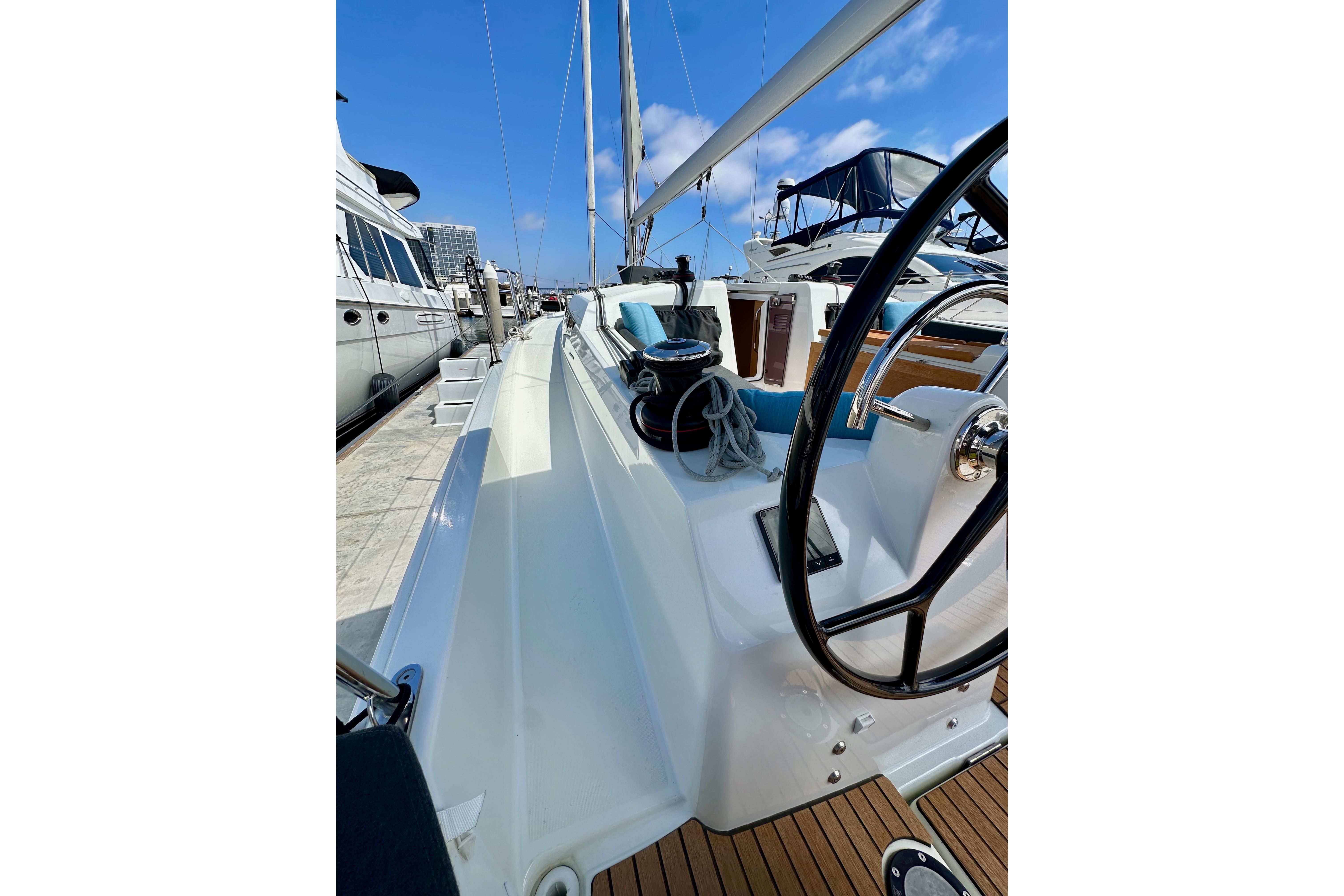 2024 Jeanneau Sun Odyssey 410 sailboat docked, showcasing sleek deck and steering wheel.