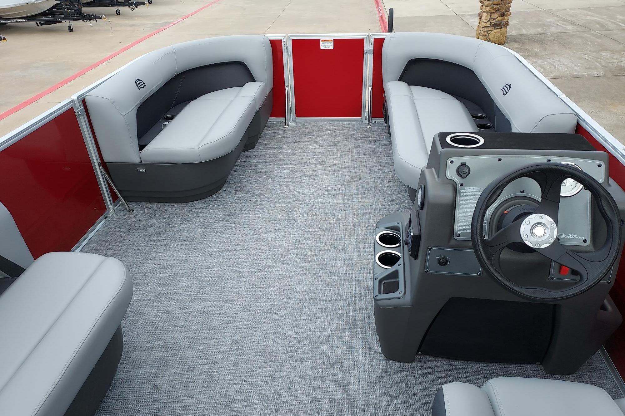 2026 Sun Tracker Party Barge 16 DLX interior with gray seating and steering console.