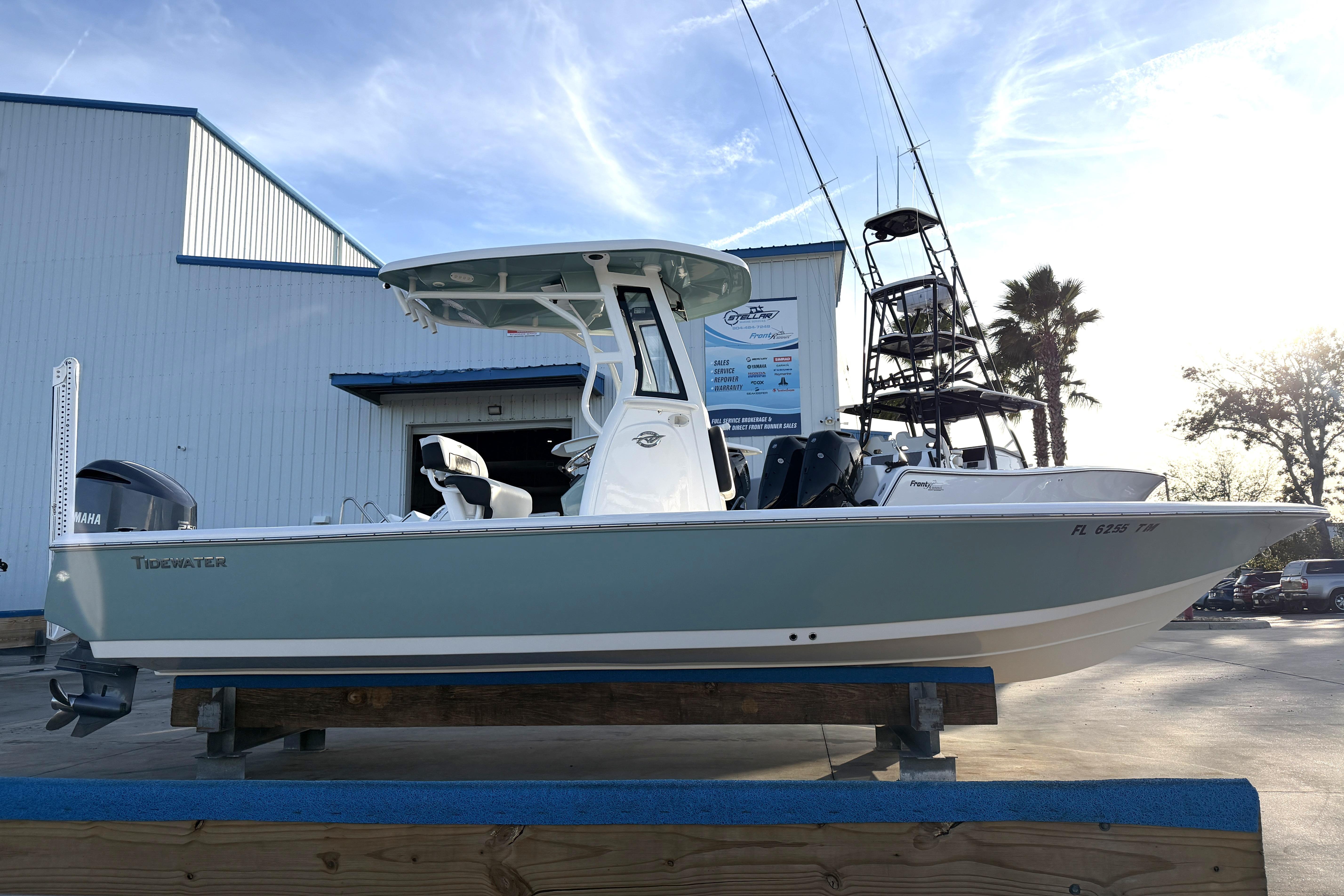 2023 Tidewater 2410 Bay Max boat displayed outdoors near a blue building.
