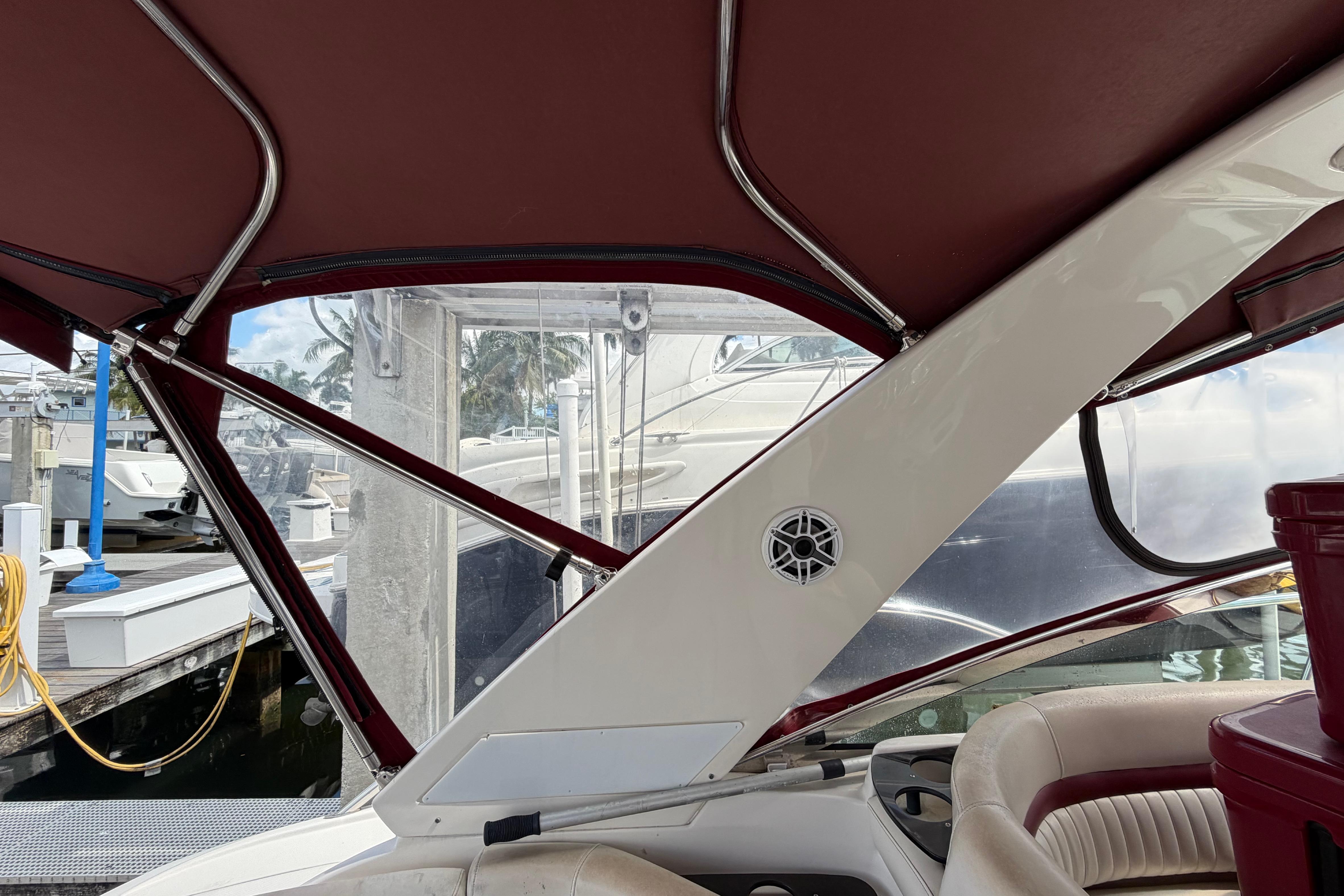 Interior view of a 2007 Monterey 350 Sport Yacht with maroon canopy and docked boats outside.