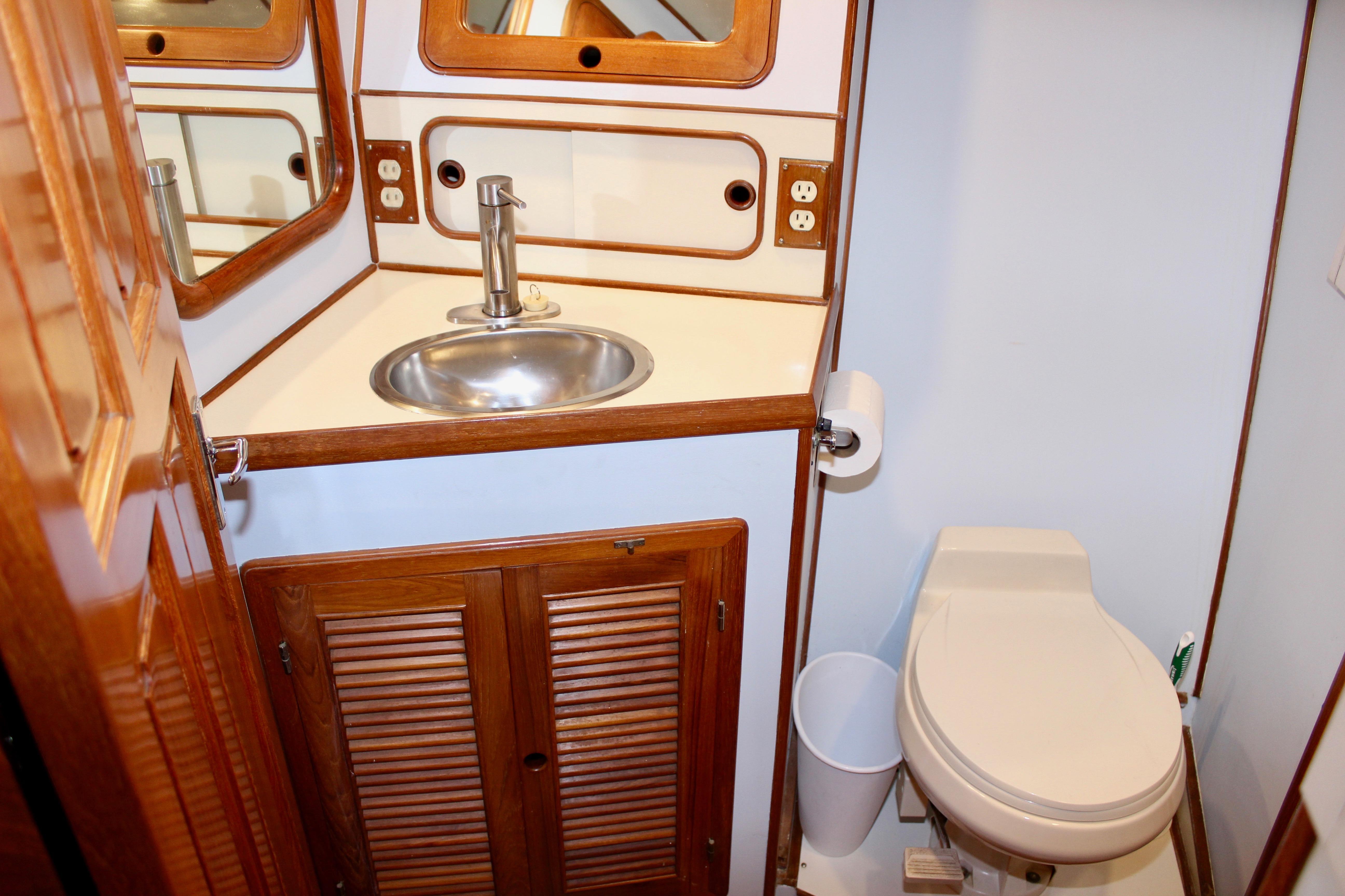 Bathroom interior of 1986 Kha Shing Spindrift 46 yacht with sink and toilet.