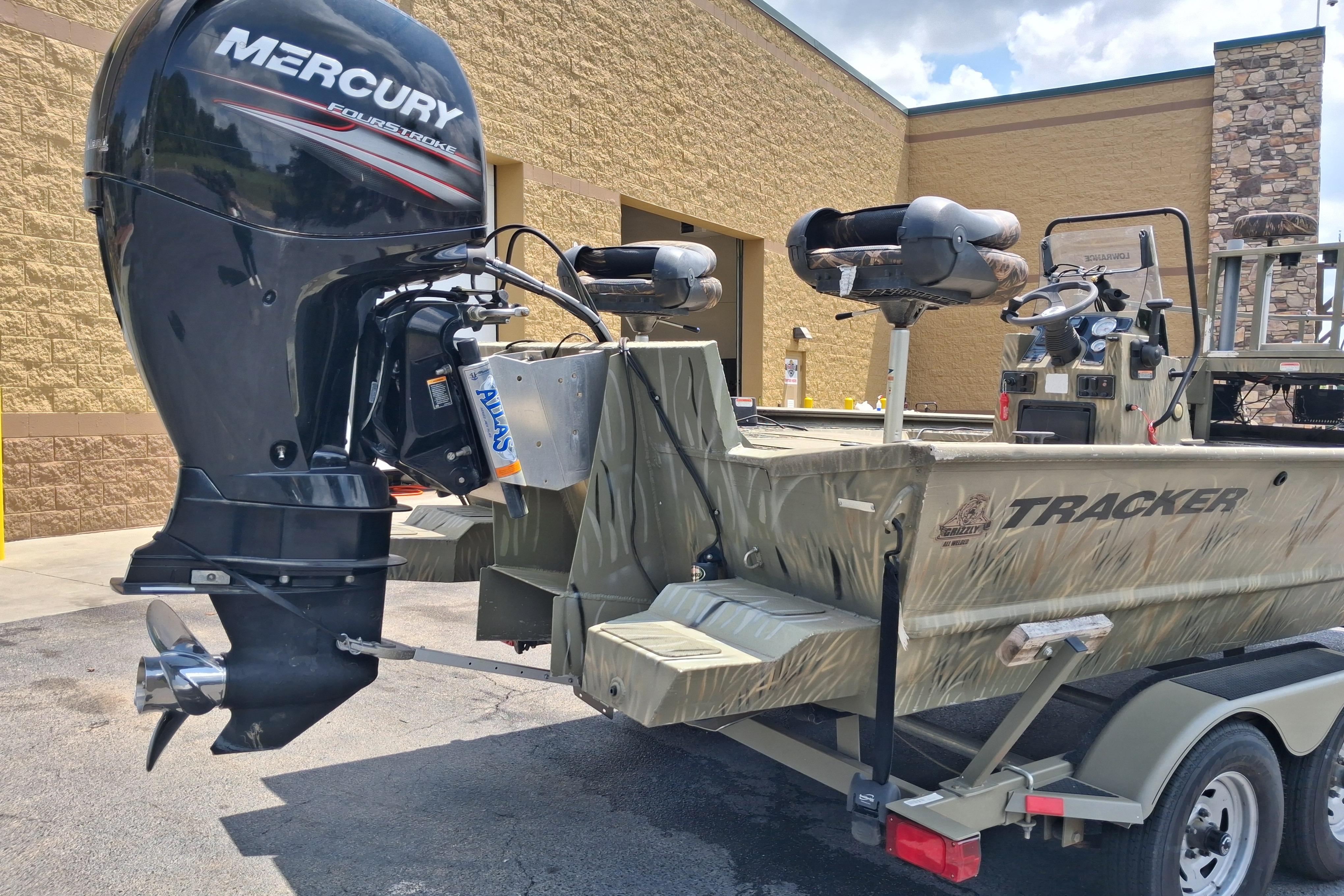 2016 Tracker Grizzly 2072 CC Sportsman boat with Mercury FourStroke engine, parked outdoors.