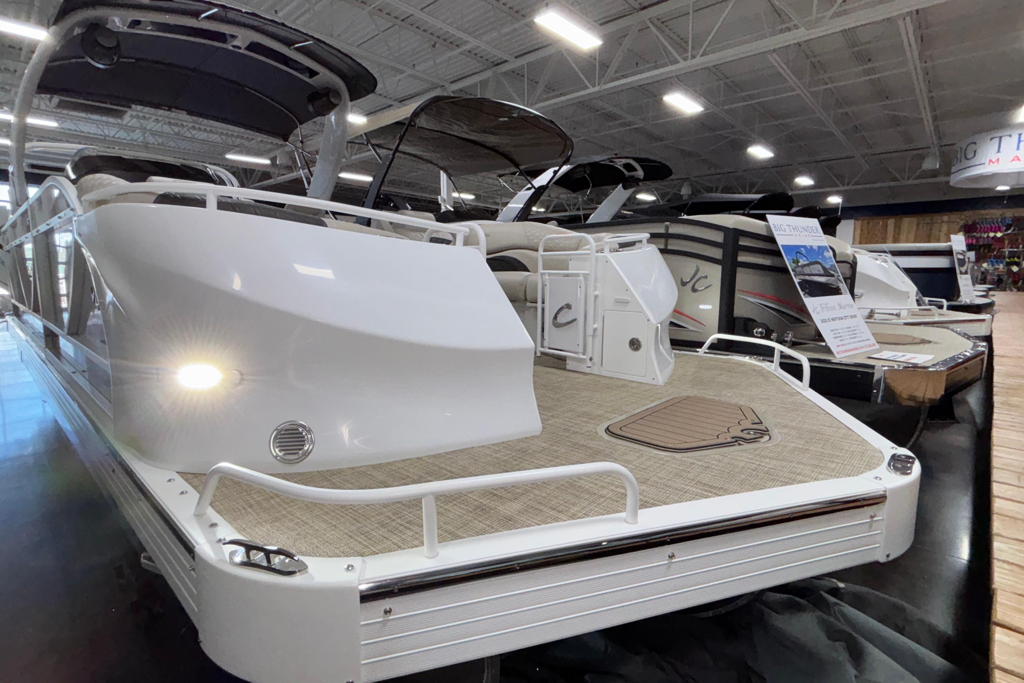 2026 JC Sporttoon 26TT pontoon boat displayed indoors at a showroom.