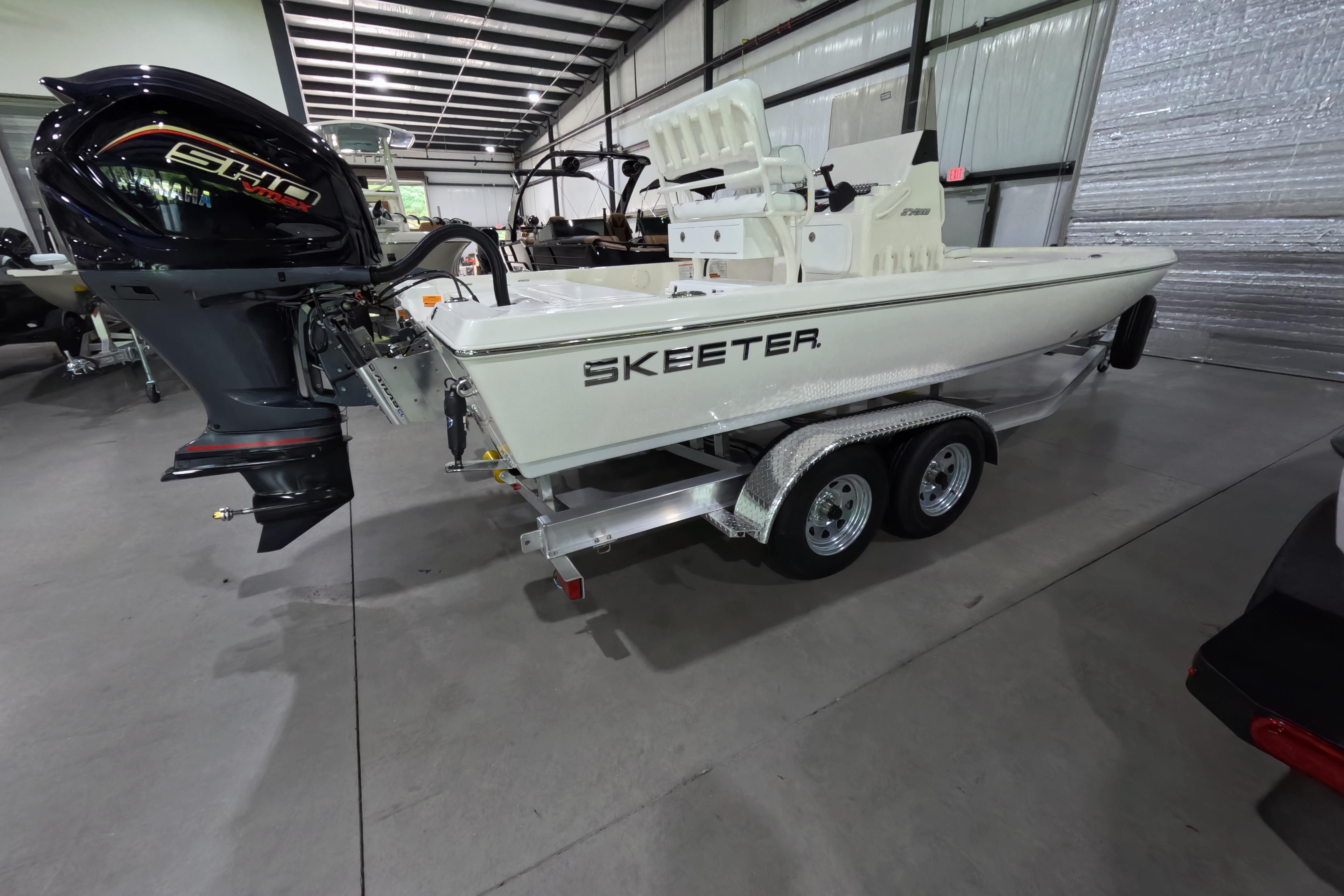 2026 Skeeter SX221 boat on trailer in indoor showroom.