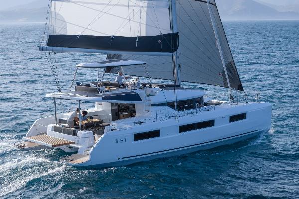 2025 Lagoon 51 ICONIC catamaran sailing on open sea, showcasing sleek design and spacious deck.